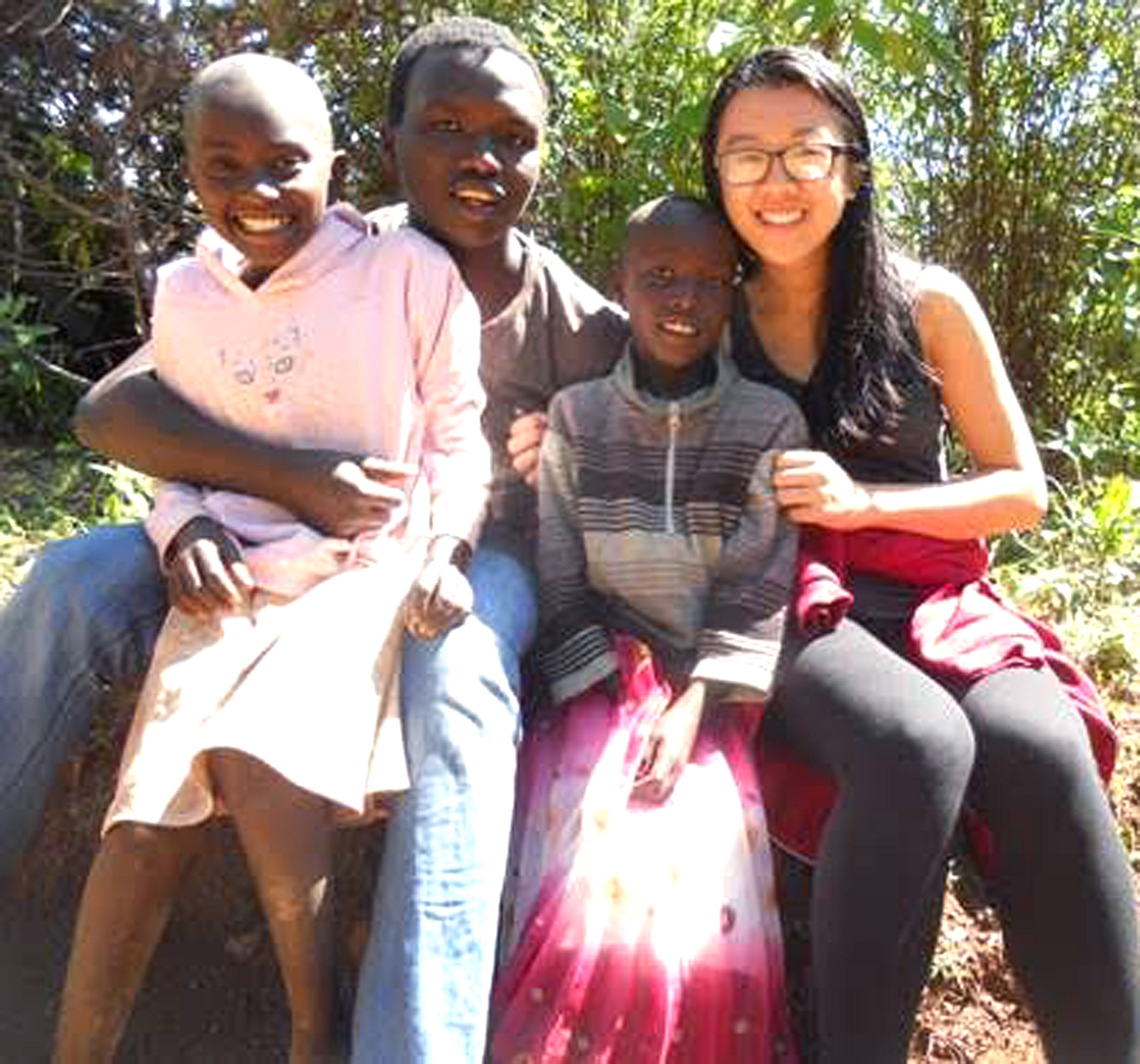 Two people and two children posing together with their arms around each other