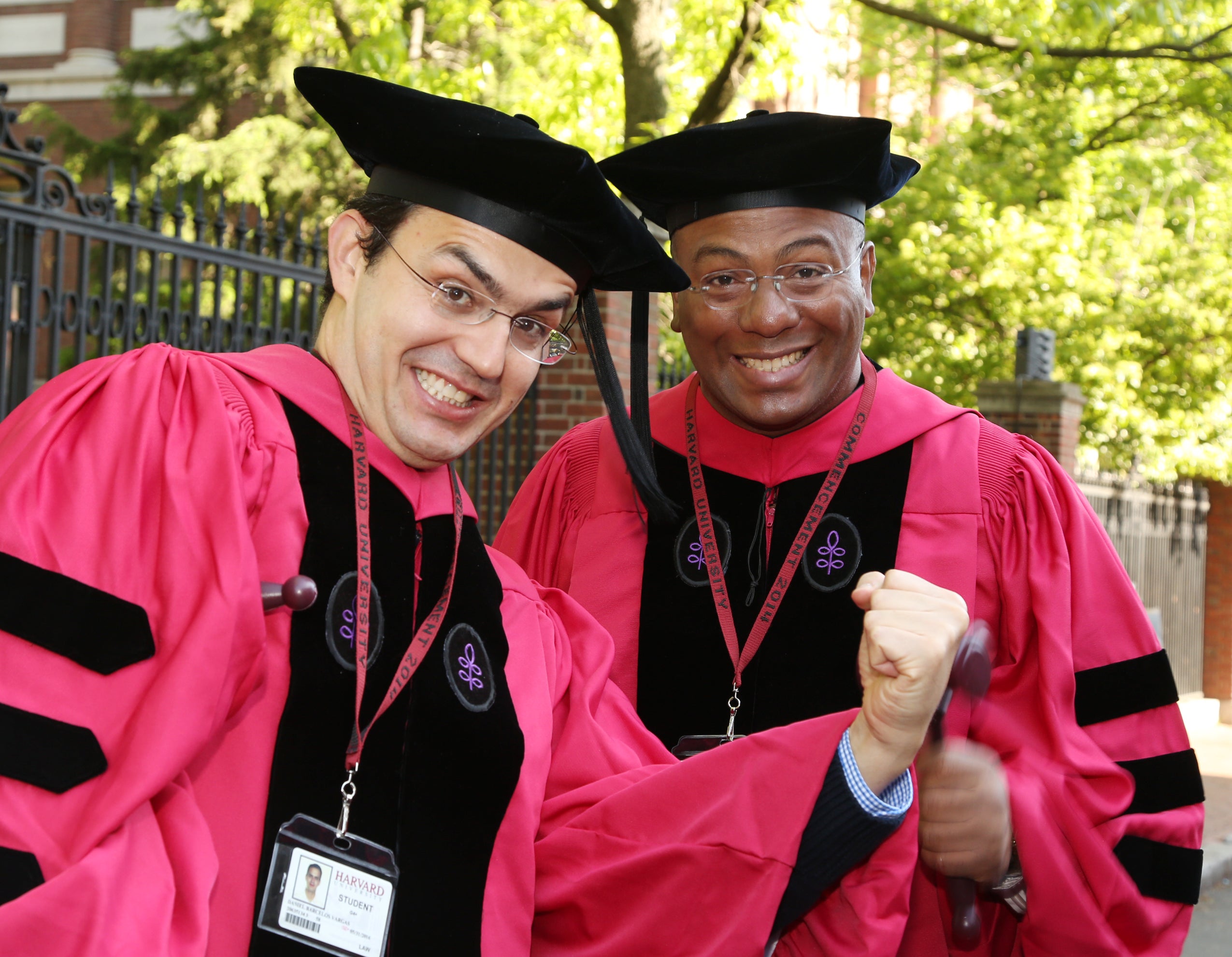 Two men in caps and gowns smiling together