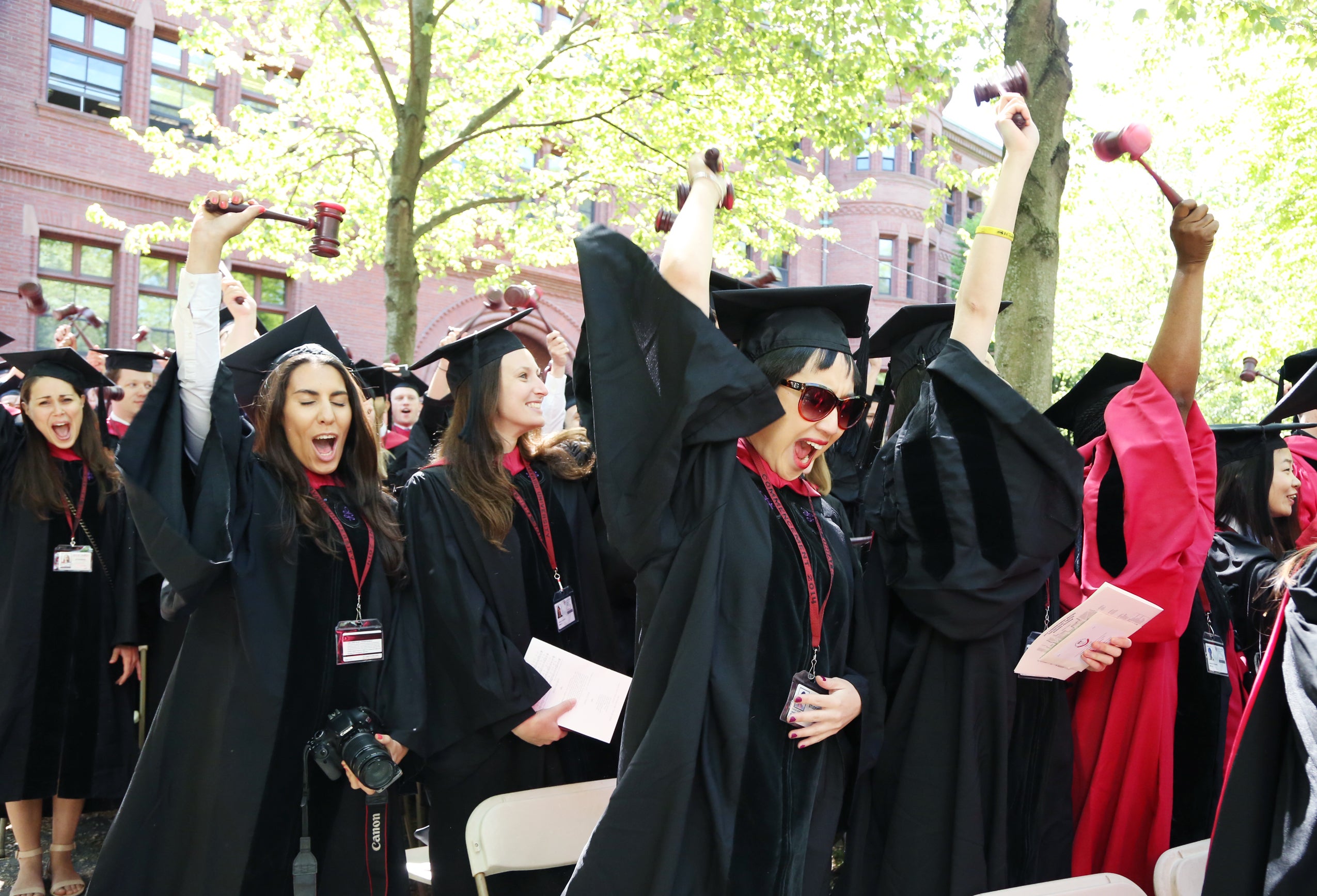 Graduates cheering and raising their gavels in the air