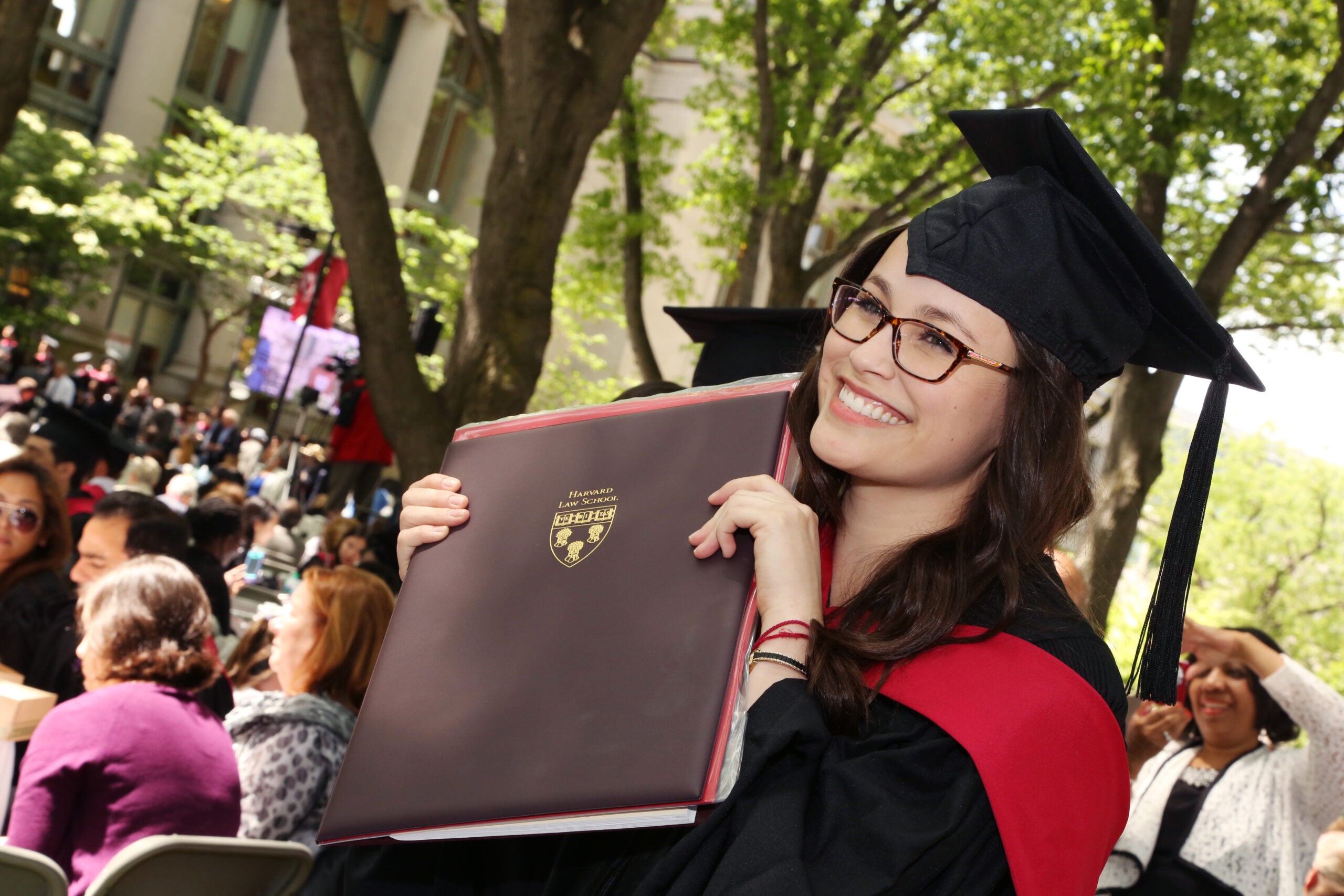 A graduate posing with her degree