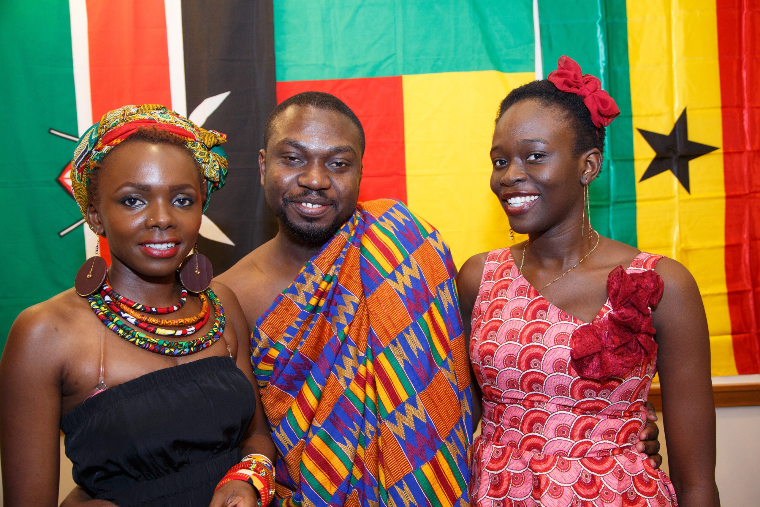 Three people posing together in traditional dress