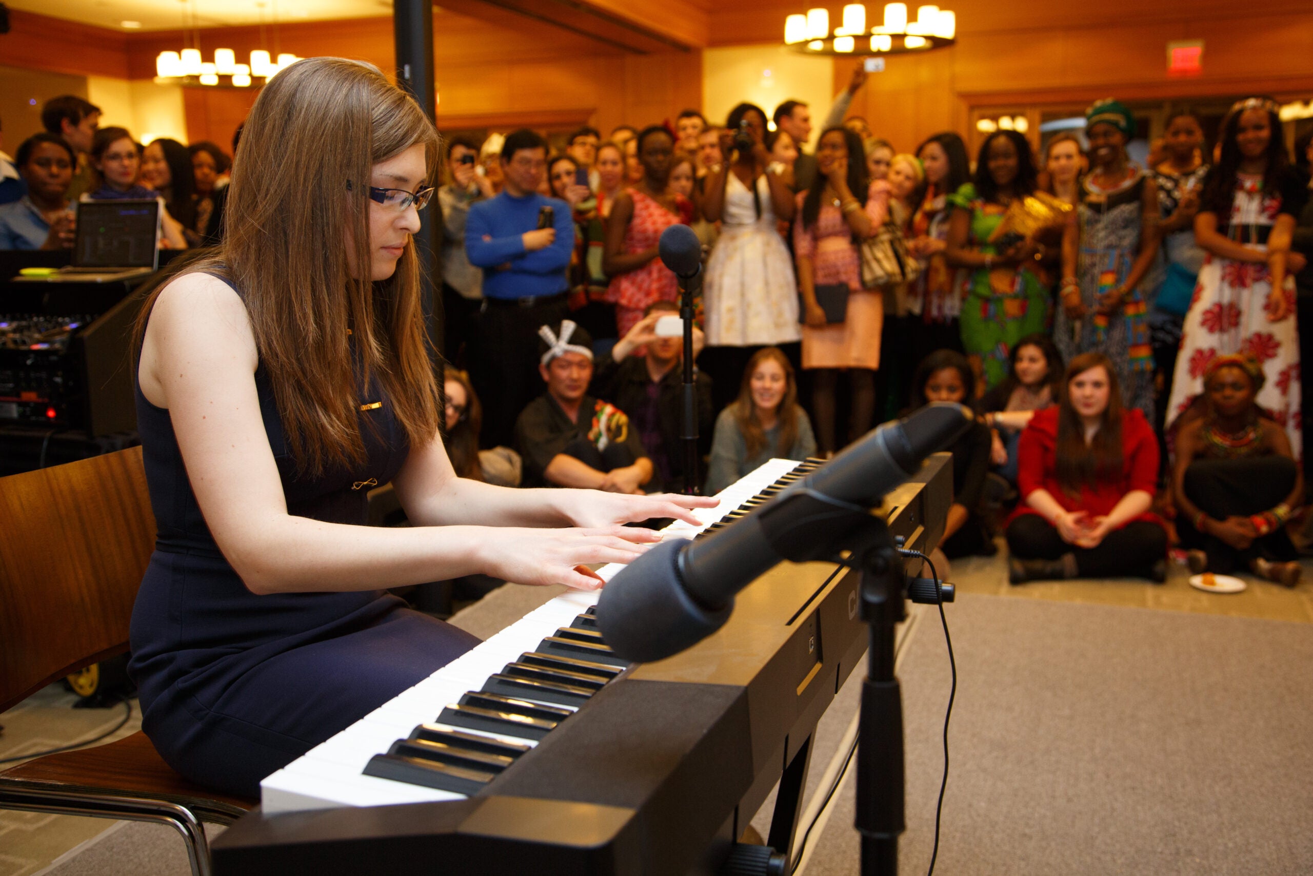 A woman playing a piano in front of an audience