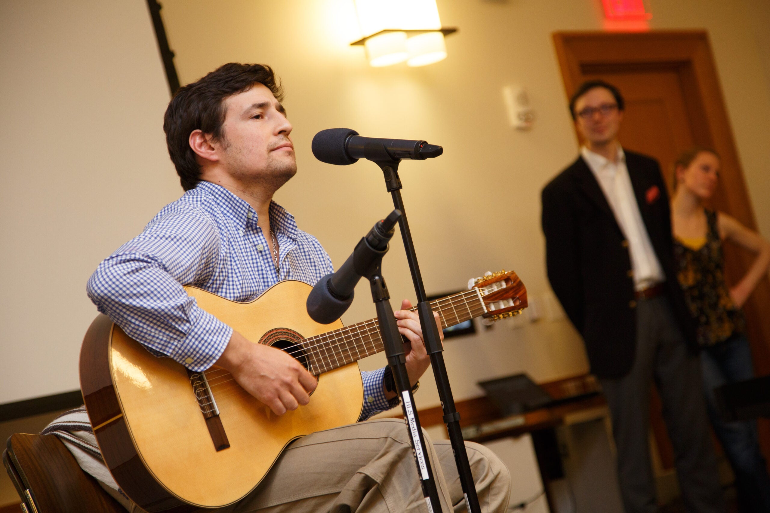 A man sitting and playing a guitar