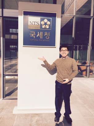 A man gesturing to a sign on a street