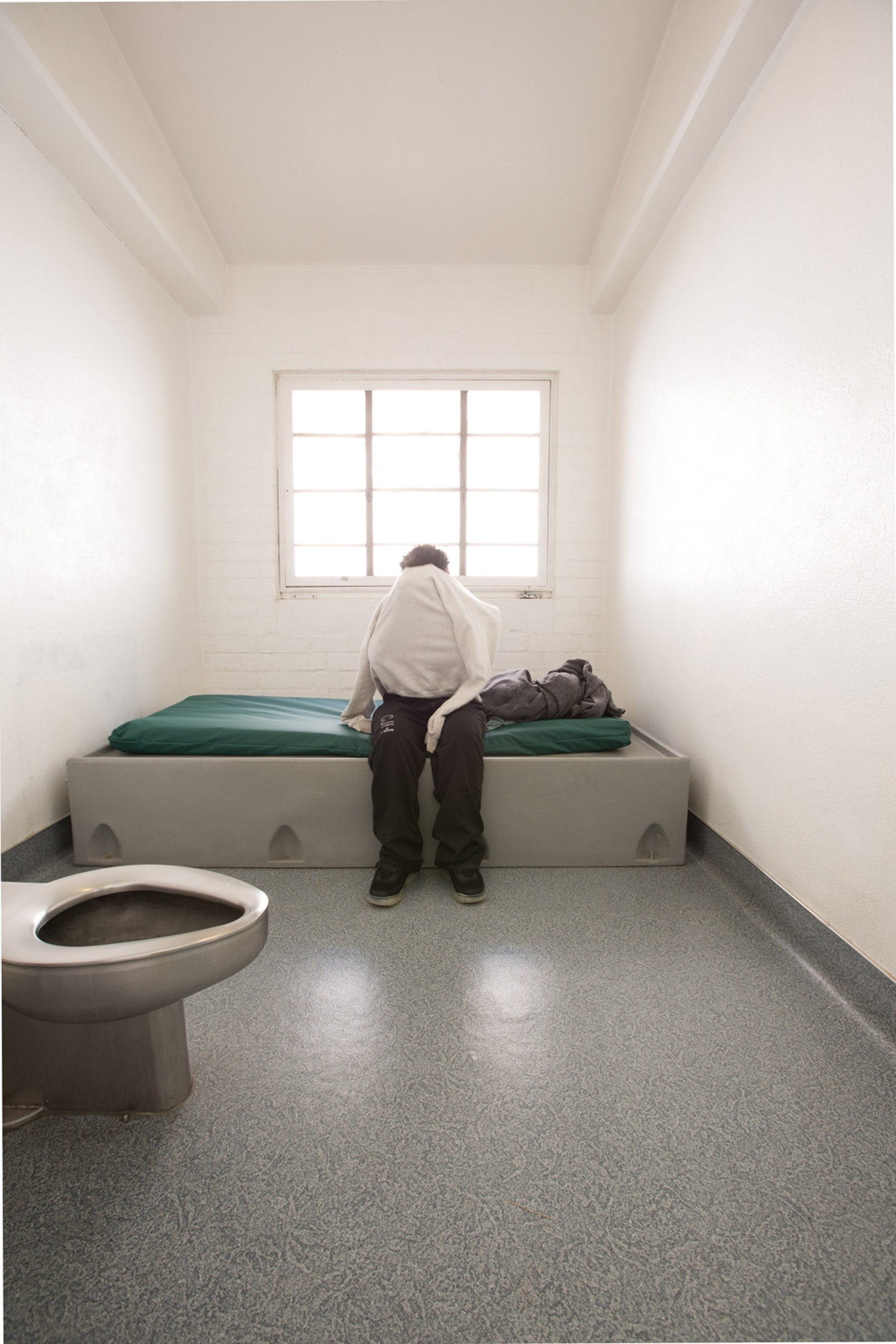 A young person in a prison cell