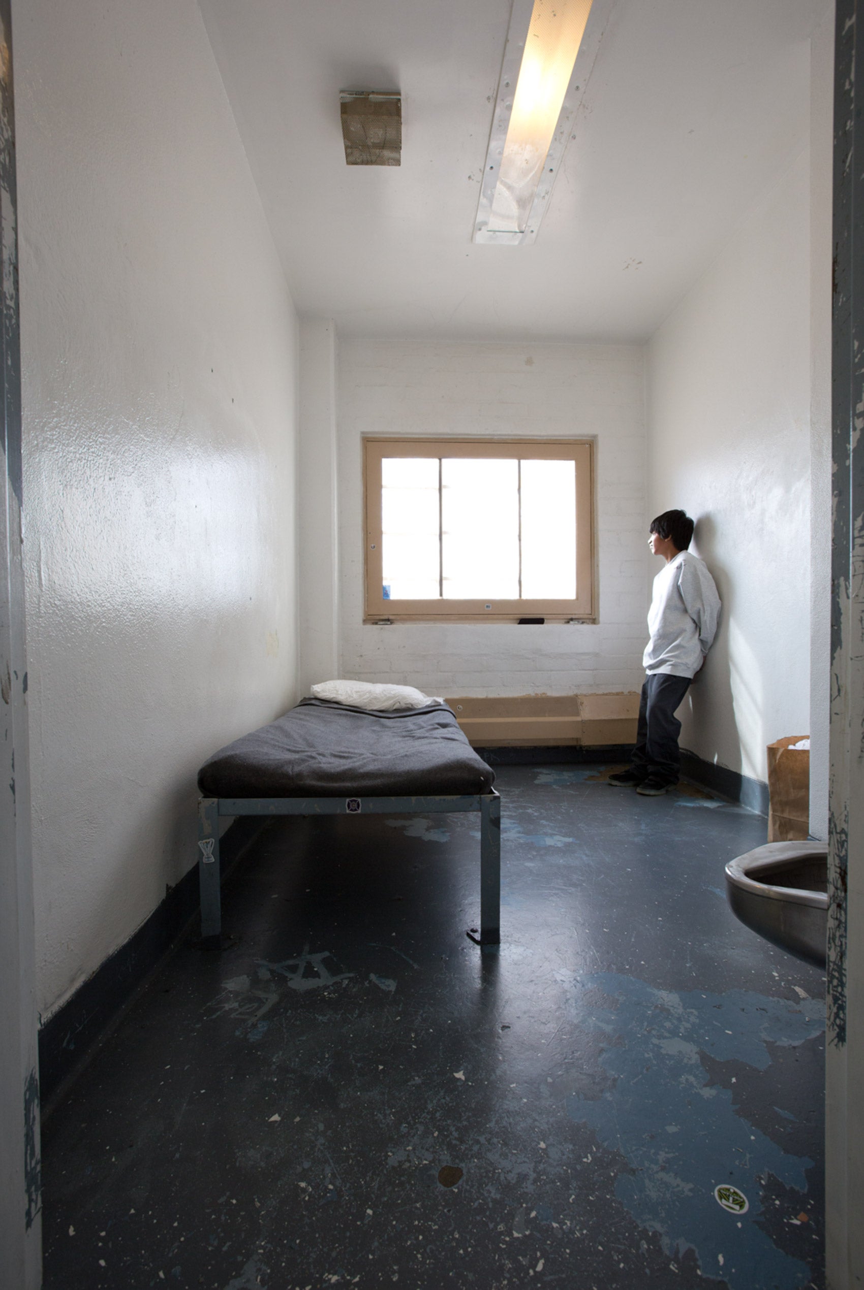 A child standing in a prison cell