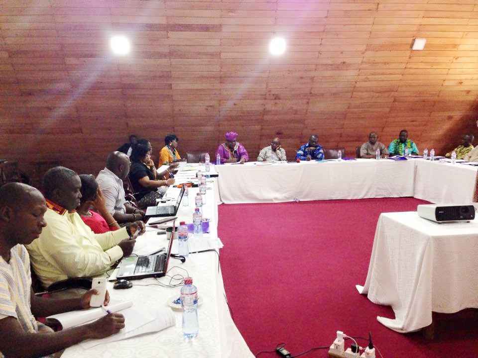 A group of people seated at a U shaped table, working on laptops