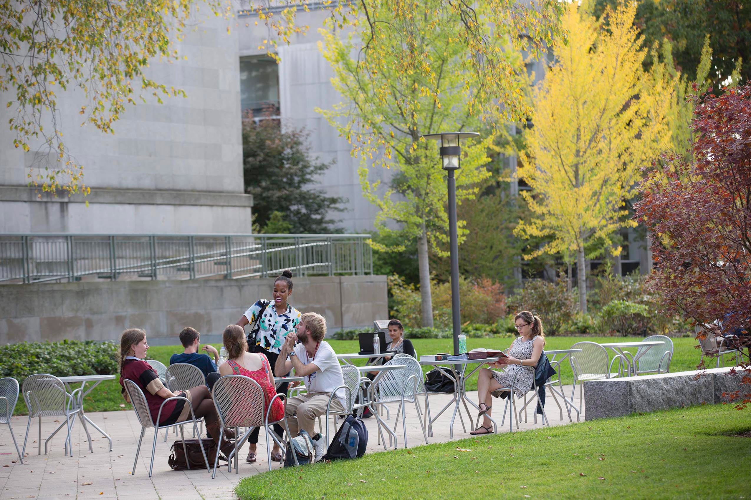 Students sitting together at tables outside Langdell Hall