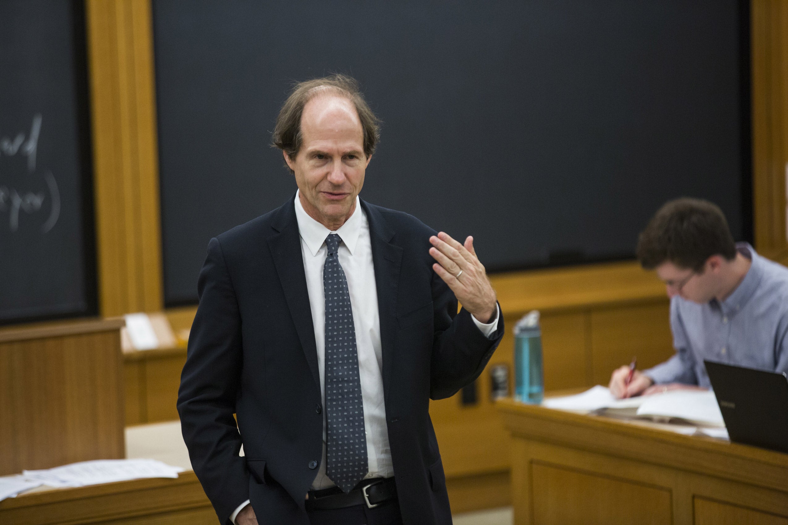 A man standing at the front of a classroom lecturing
