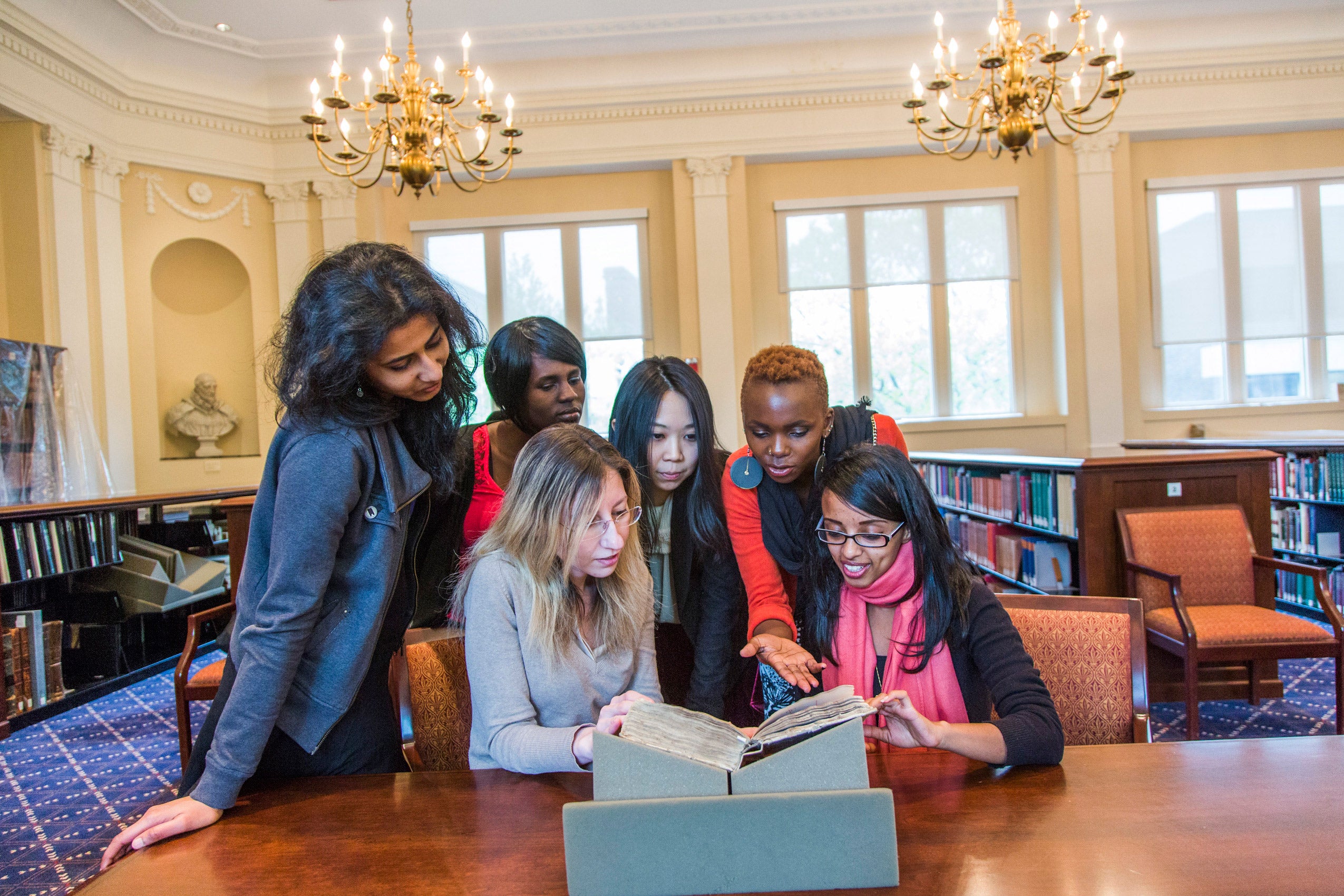 Students sitting at a table studying a book