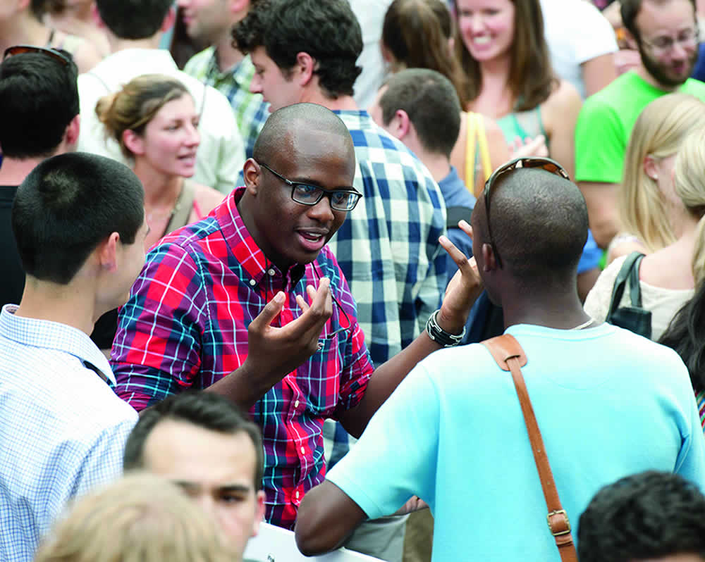 two students talking in a large group