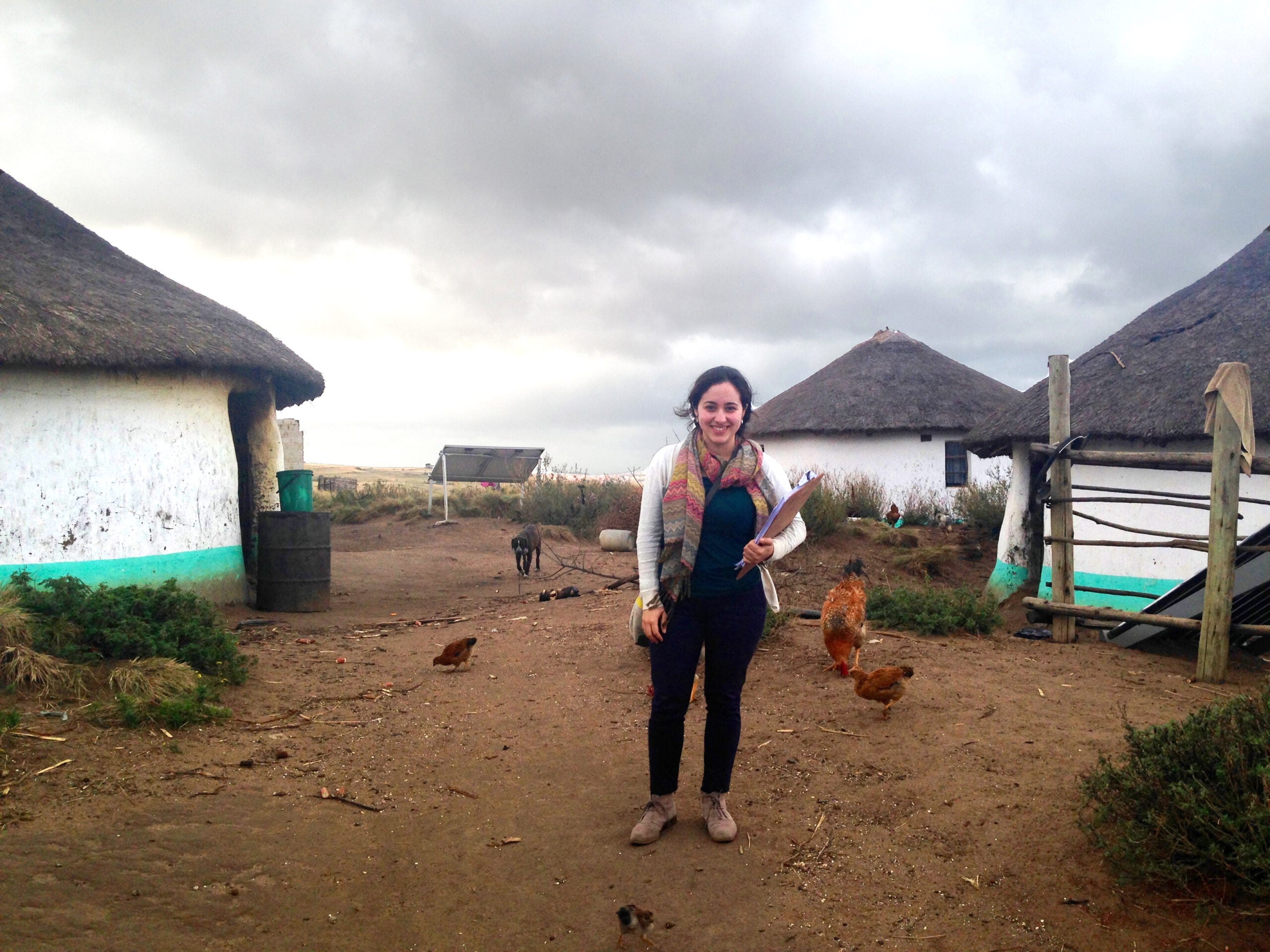 A woman standing in front of some huts