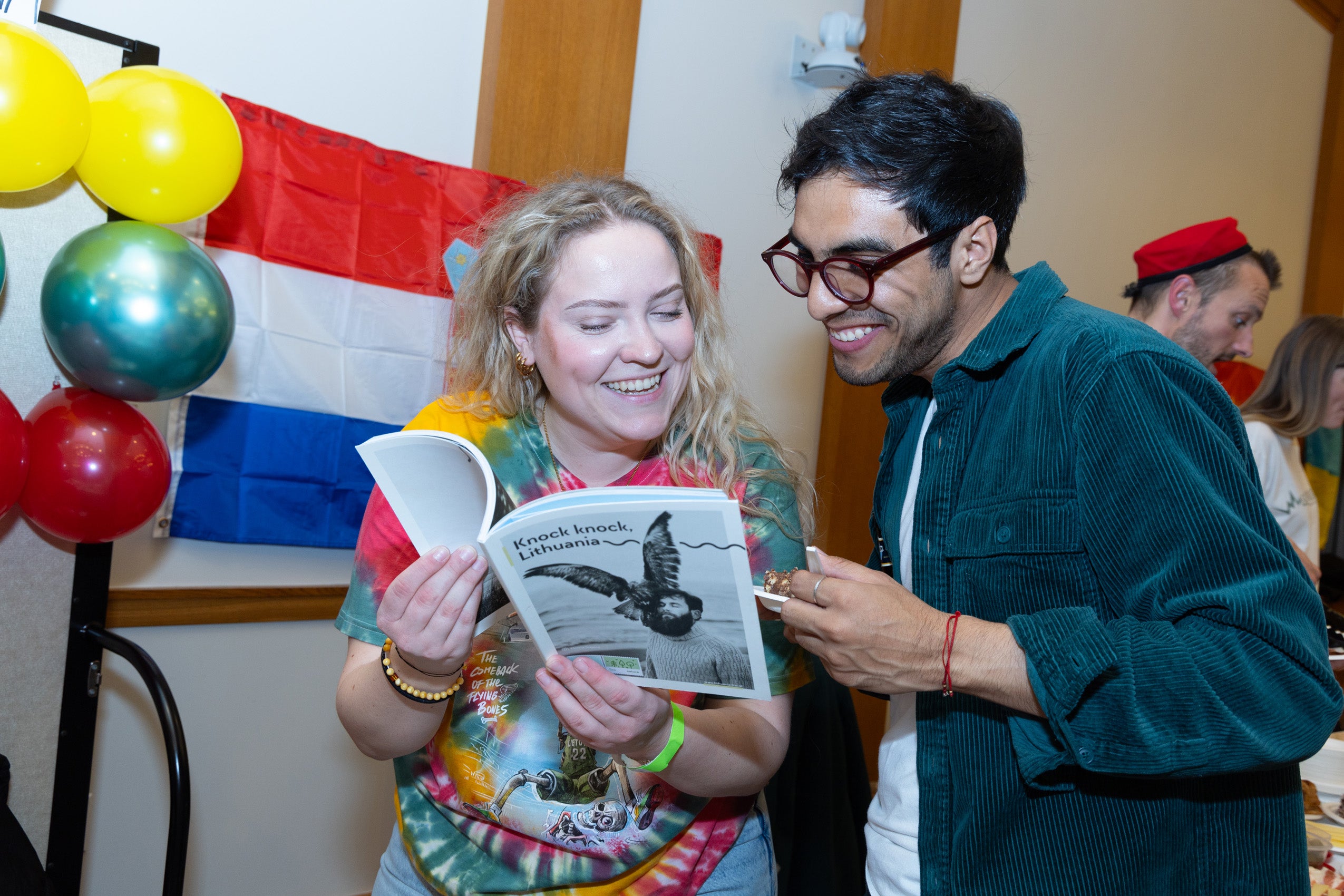 A women and man smile as they look at a booklet. in a leave