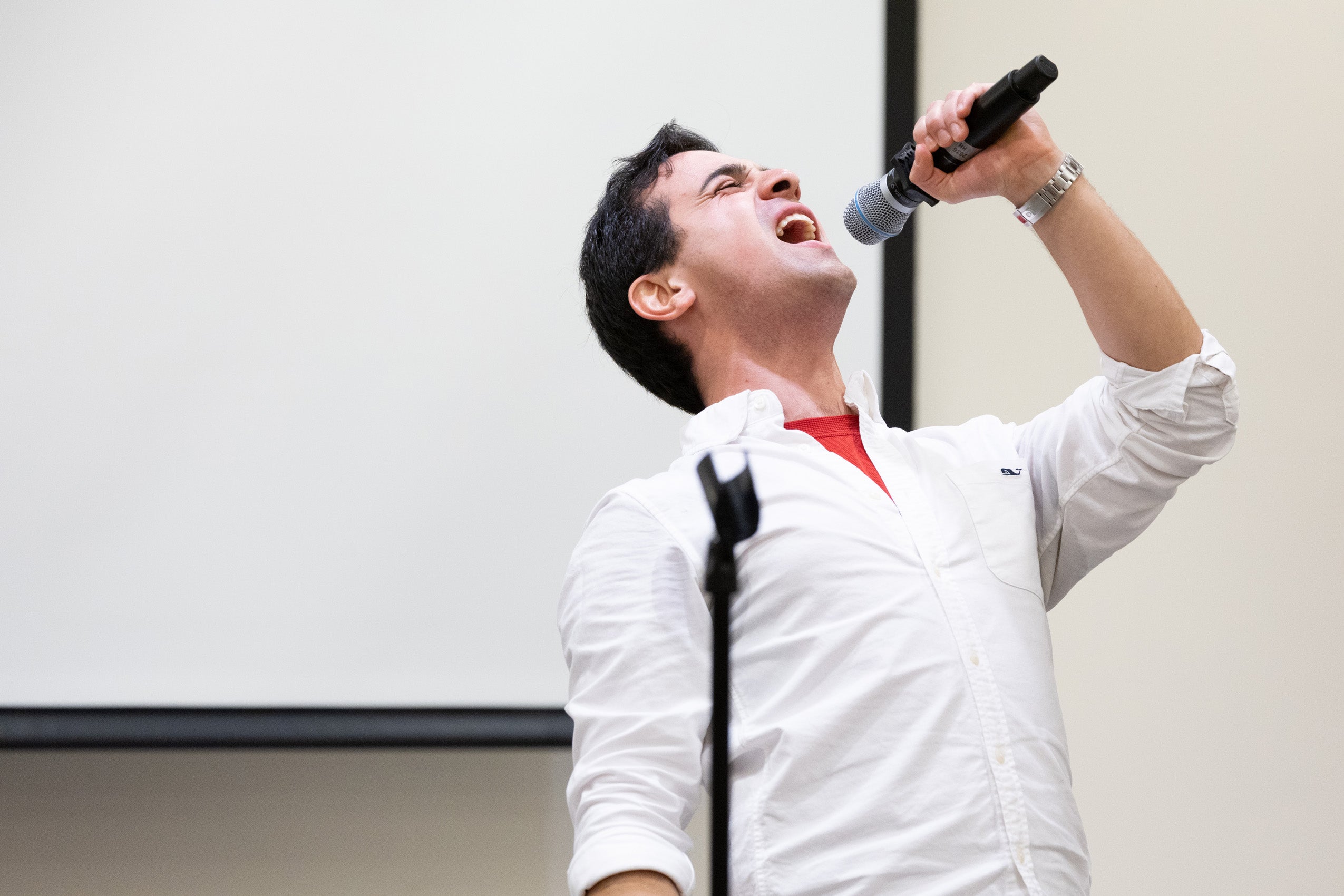 A man holding a microphone sings.