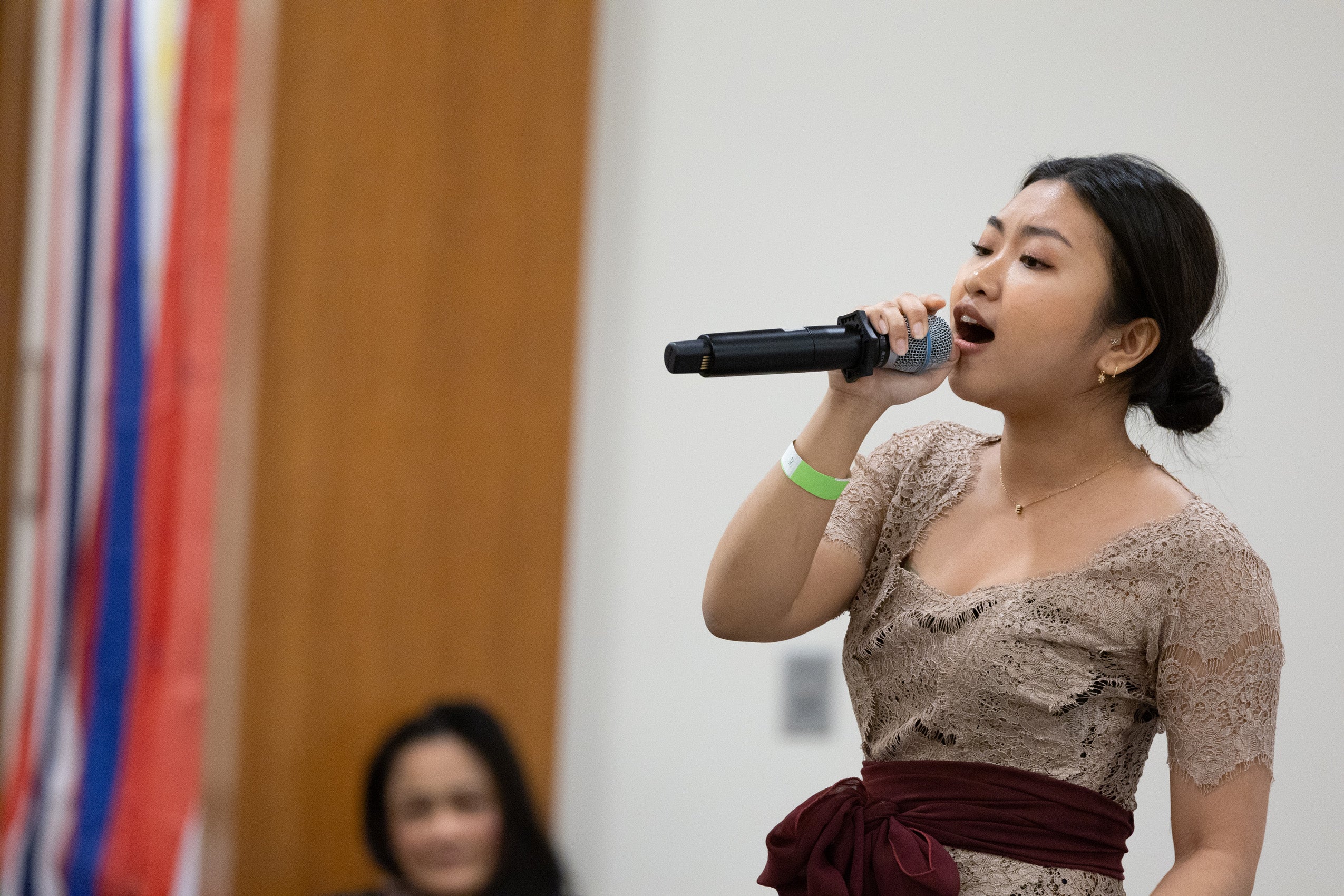 A woman singing into a microphone on a stage.