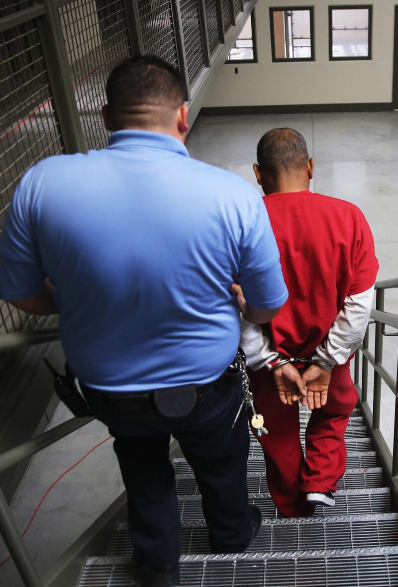 Guard escorting ICE detainee.