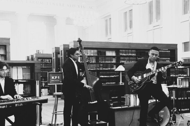 Students Cosimo Fabrizio and Shaan Pandiri playing jazz instruments in Langdell Library Reading Room