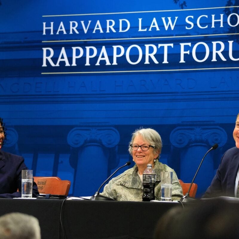 Three panelists laughing at Harvard Law School Rappaport Forum