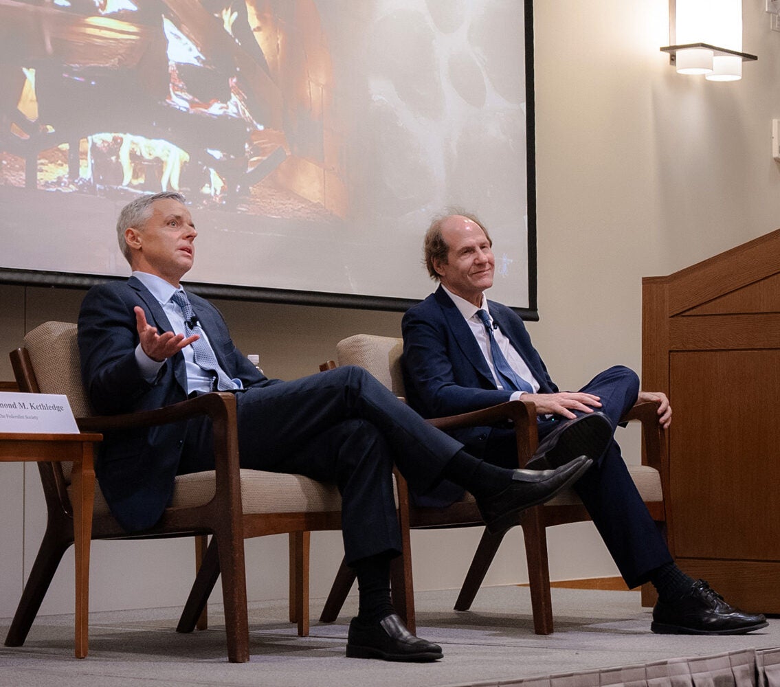 Two men speaking to an audience.