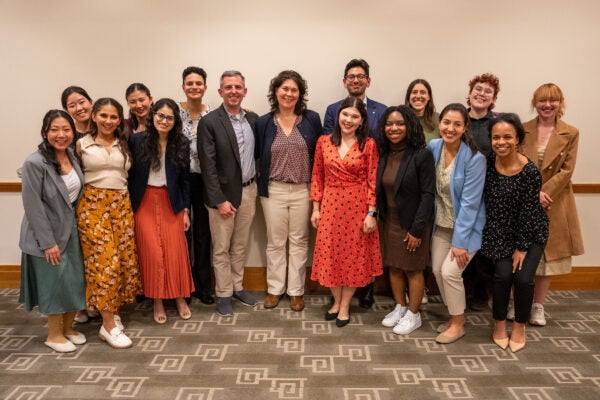 a group of students and instructors pose for a photo, smiling