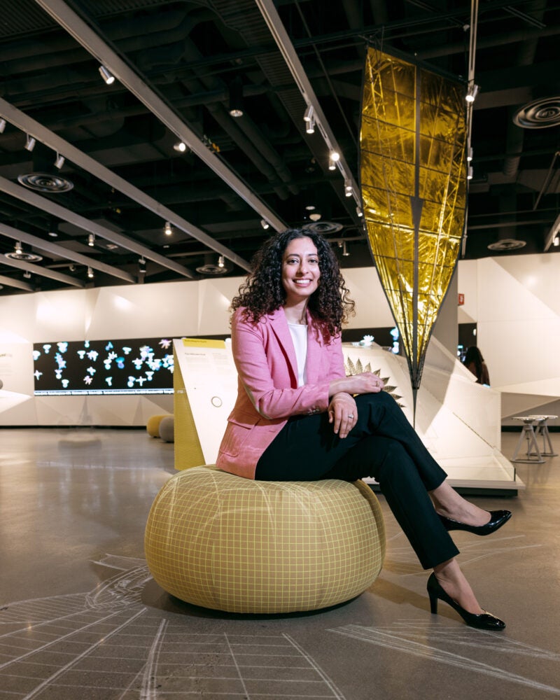 Portrait of woman sitting on a soft pillow in a museum