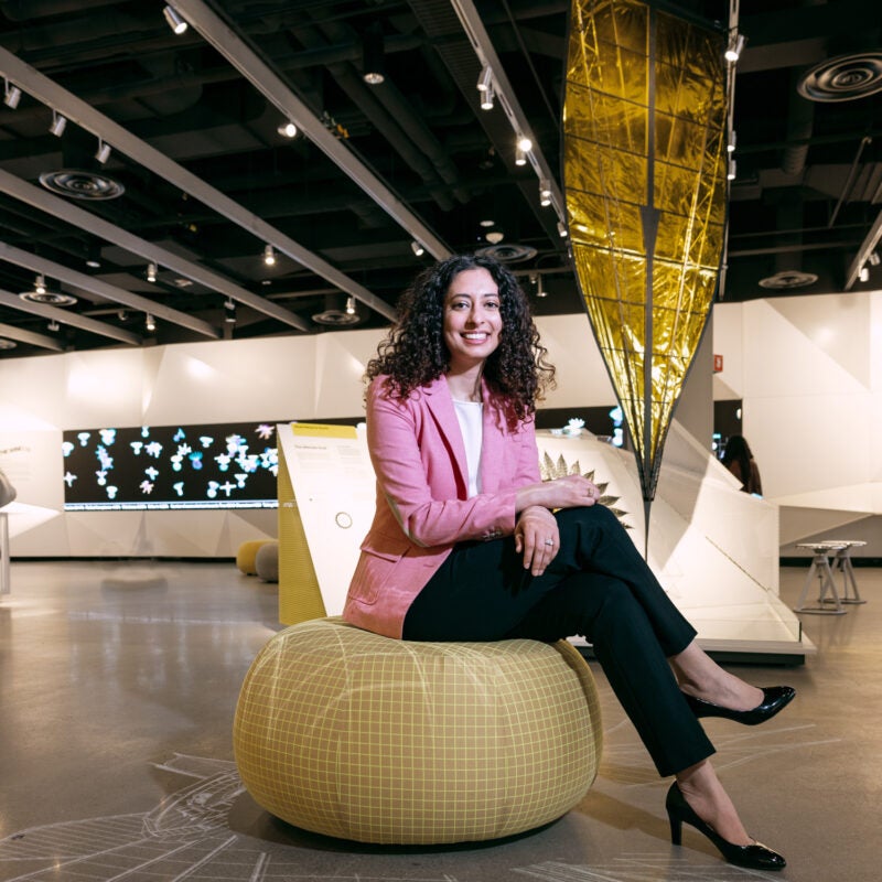 Portrait of woman sitting on a soft pillow in a museum