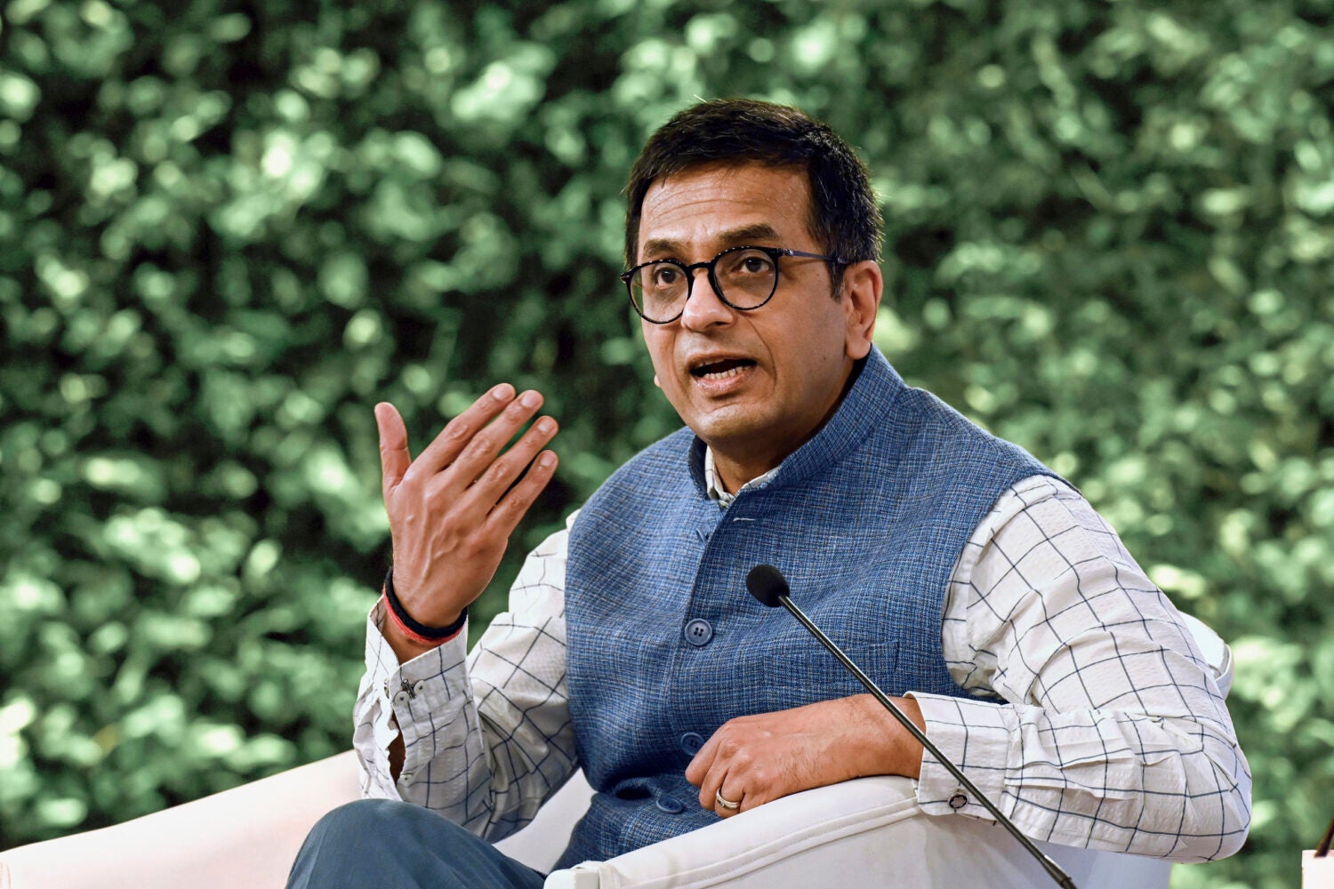 A portrait of a man sitting speaking into a microphone