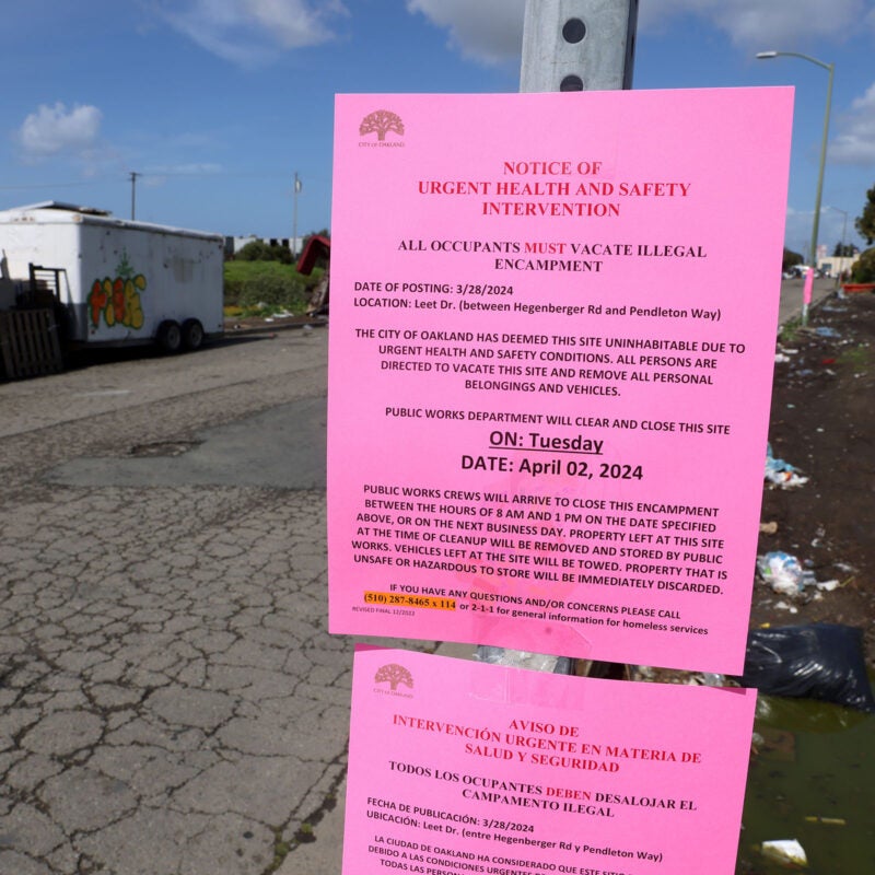 Notices to vacate encampment on signpost.