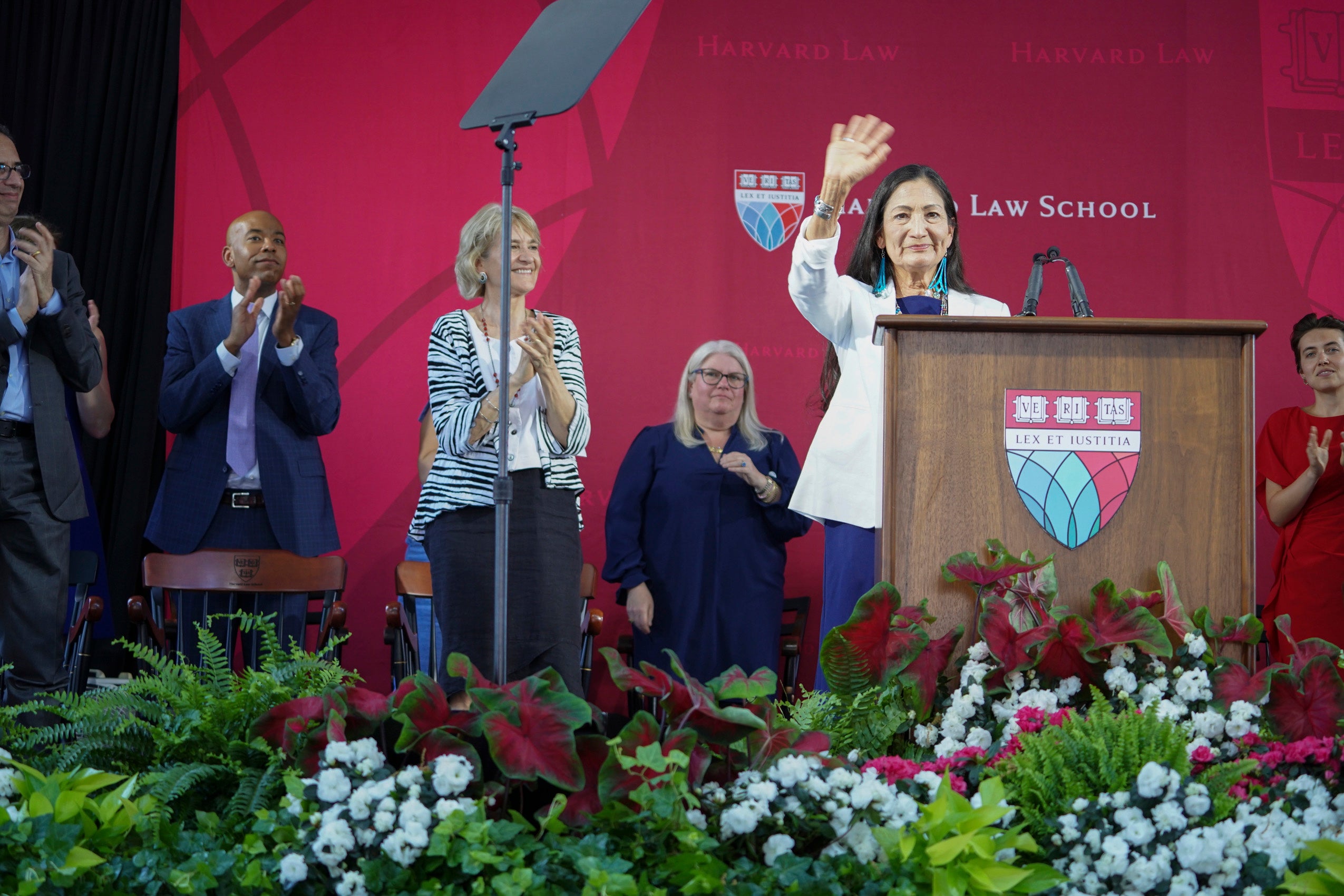 A woman waving from behind a podium
