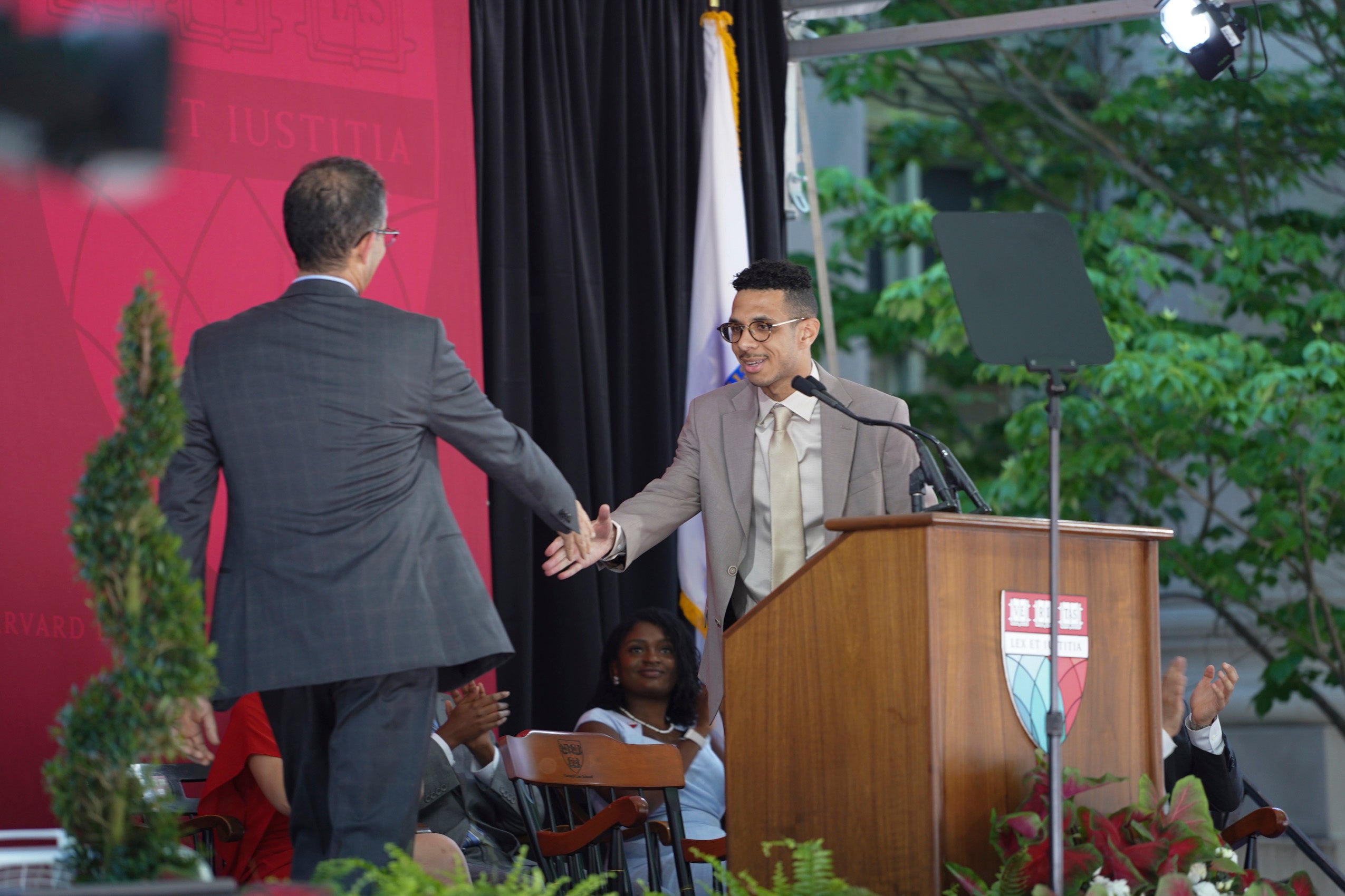 Two people on stage, shaking hands