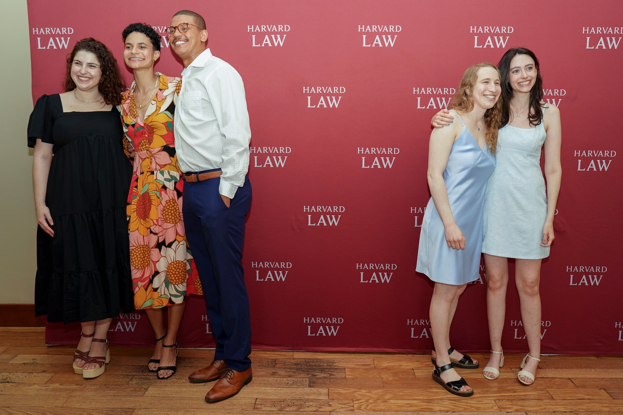 People in front of a step and repeat taking photos