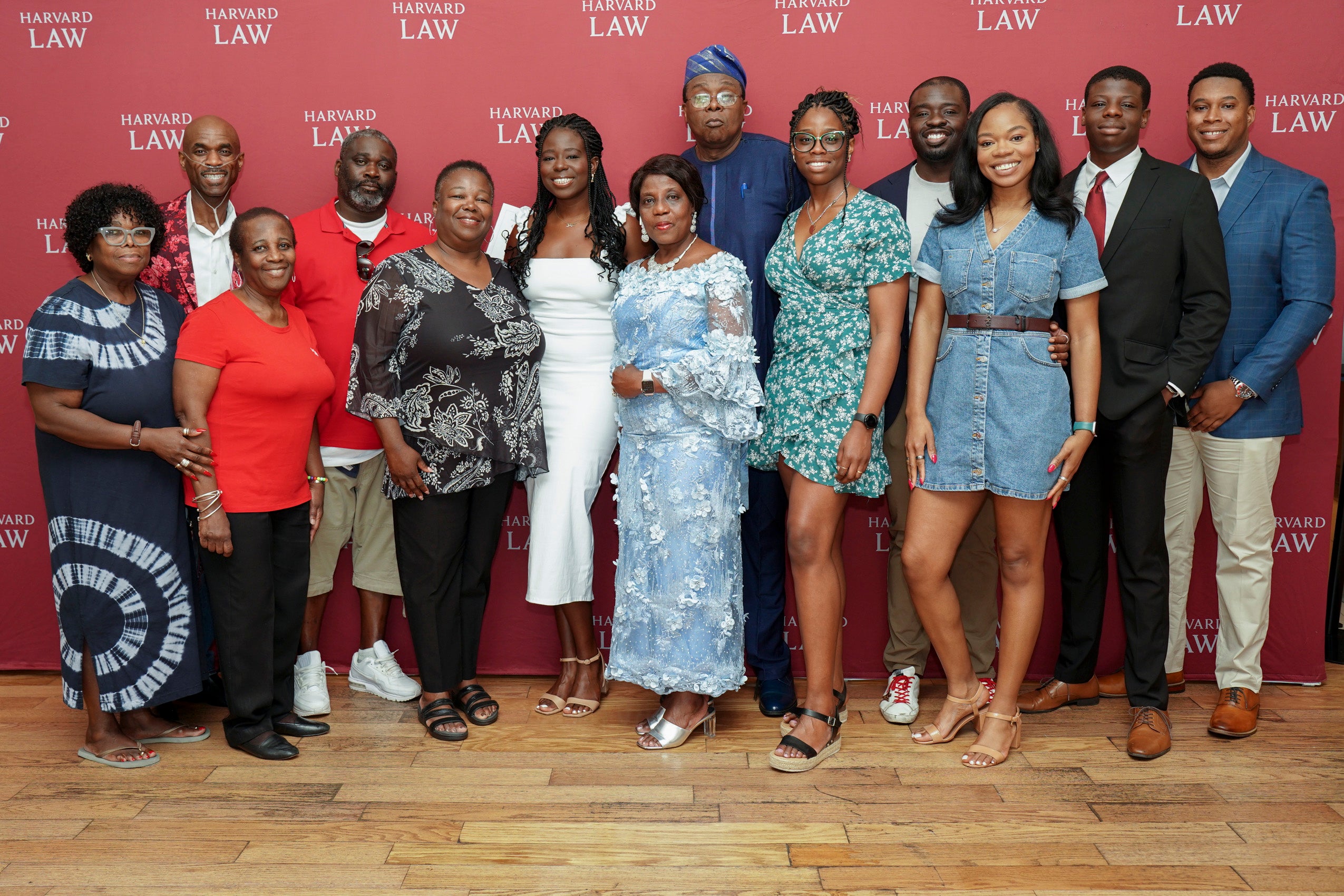 A group of people having their photo taken in front of a step and repeat