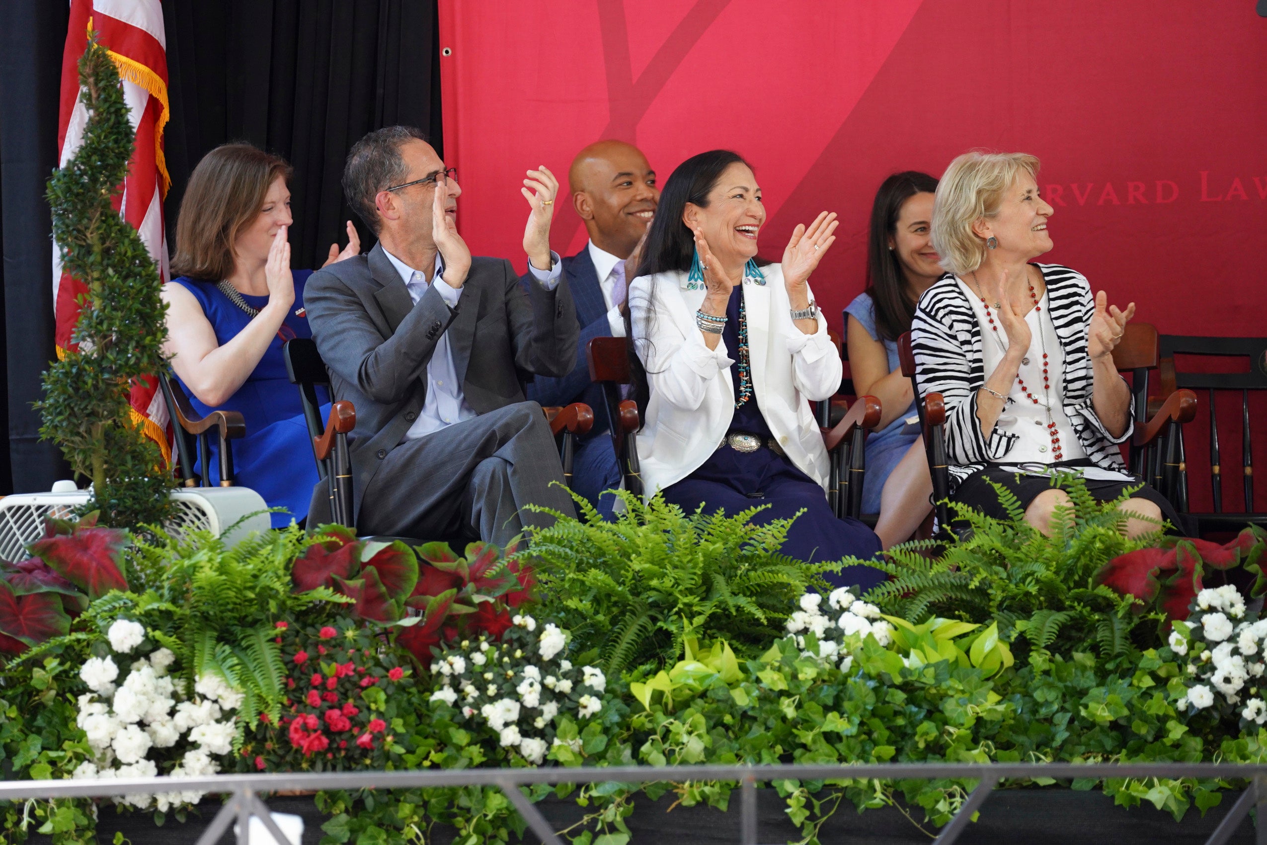 A group of people on stage, applauding