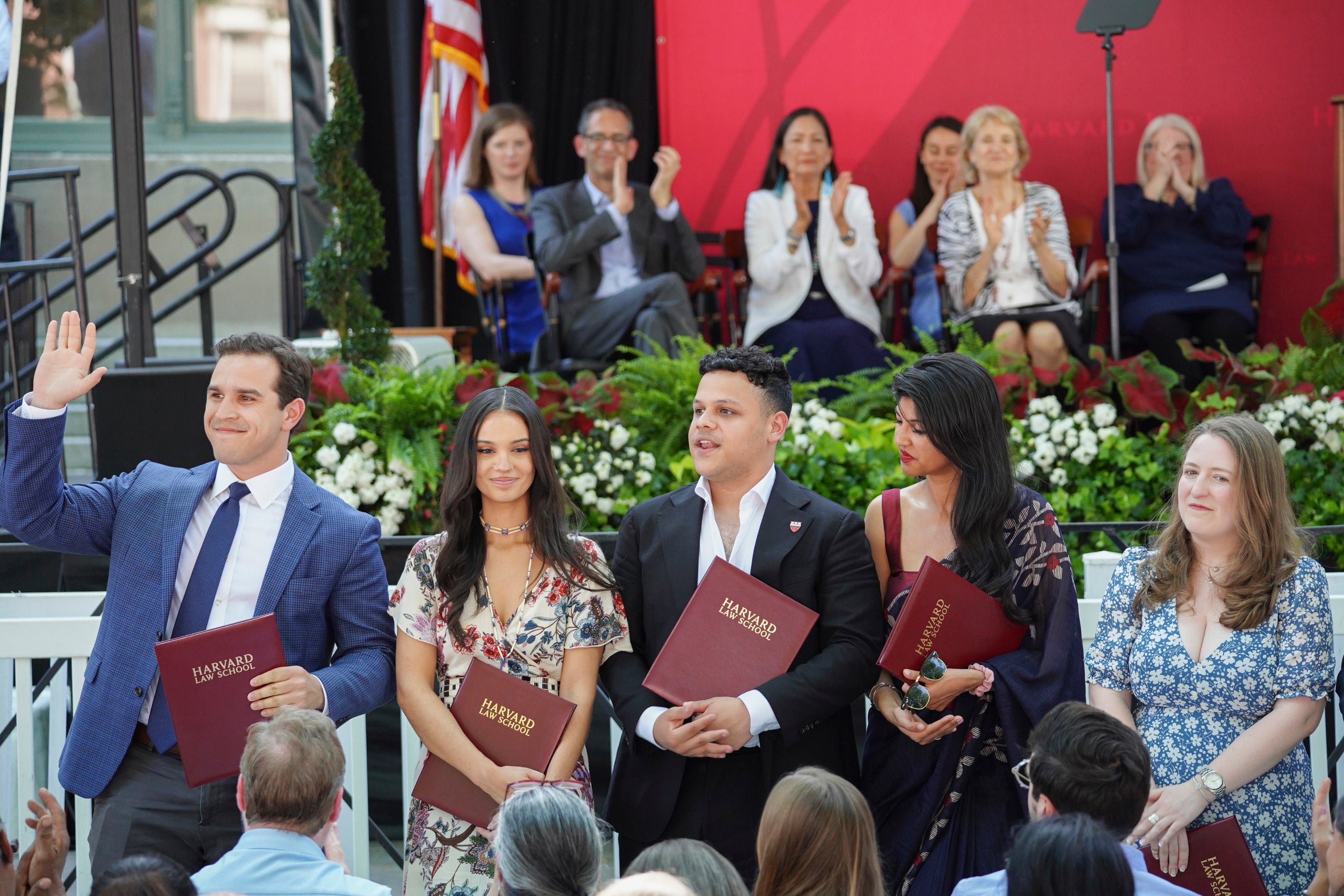 Graduating students standing together, holding their awards