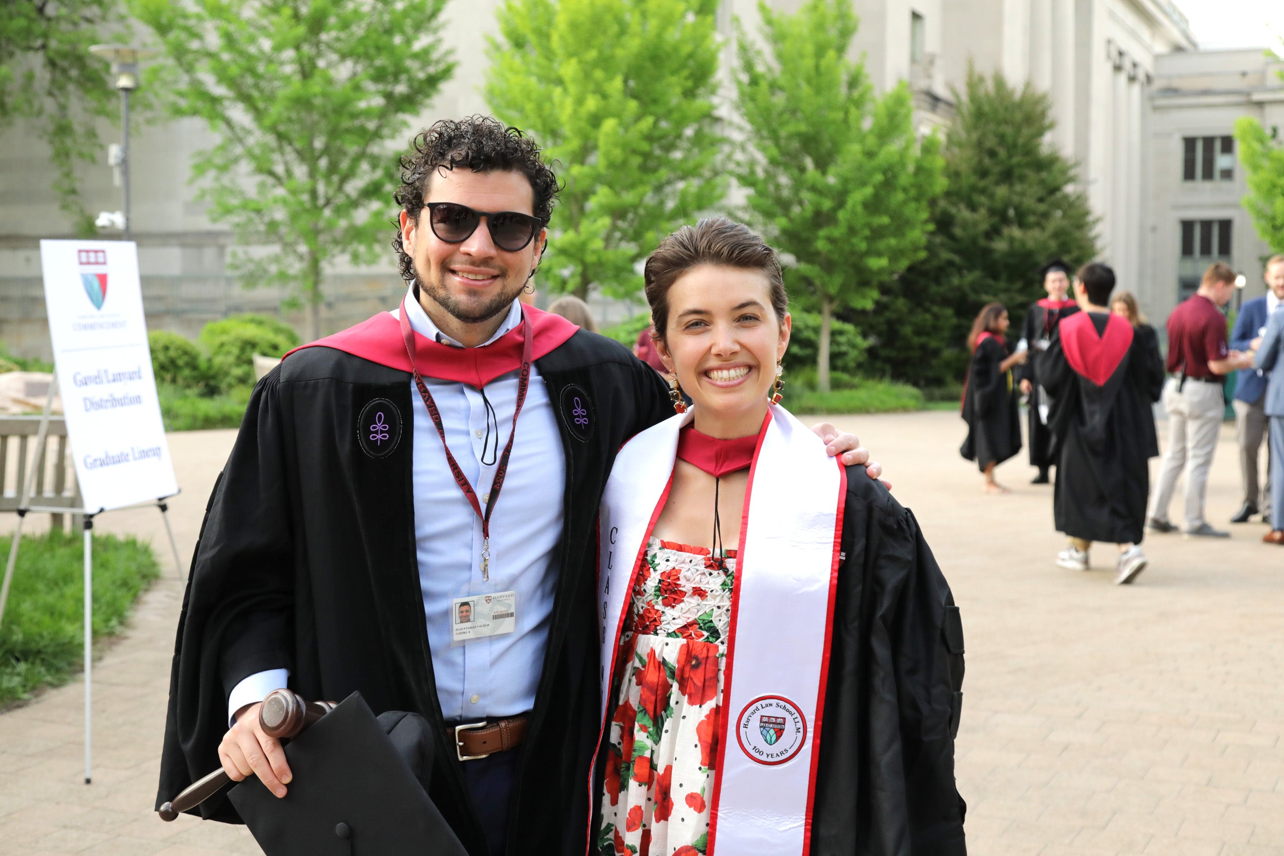 Two students standing together in Commencement regalia