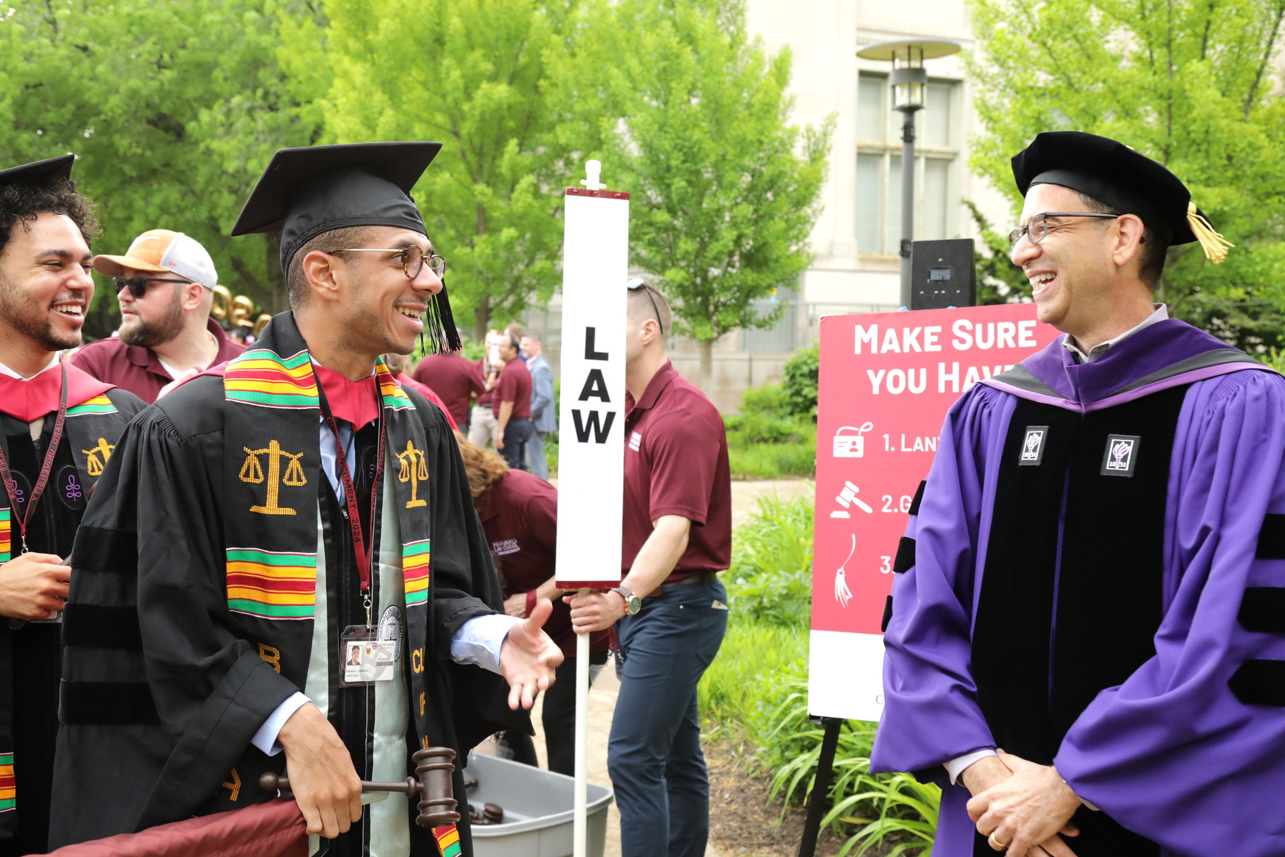 A graduating student and Dean of the law school smiling and chatting