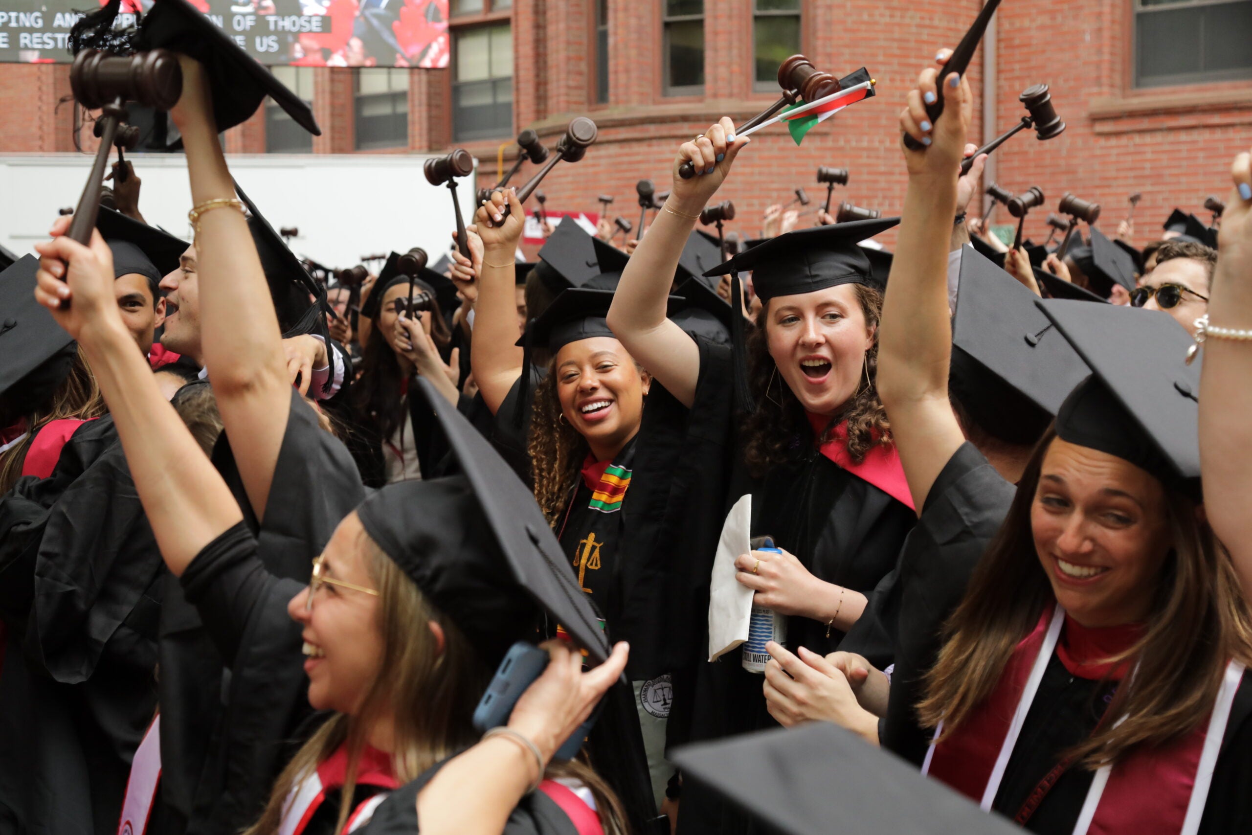 Graduates smiling and raising their gavels