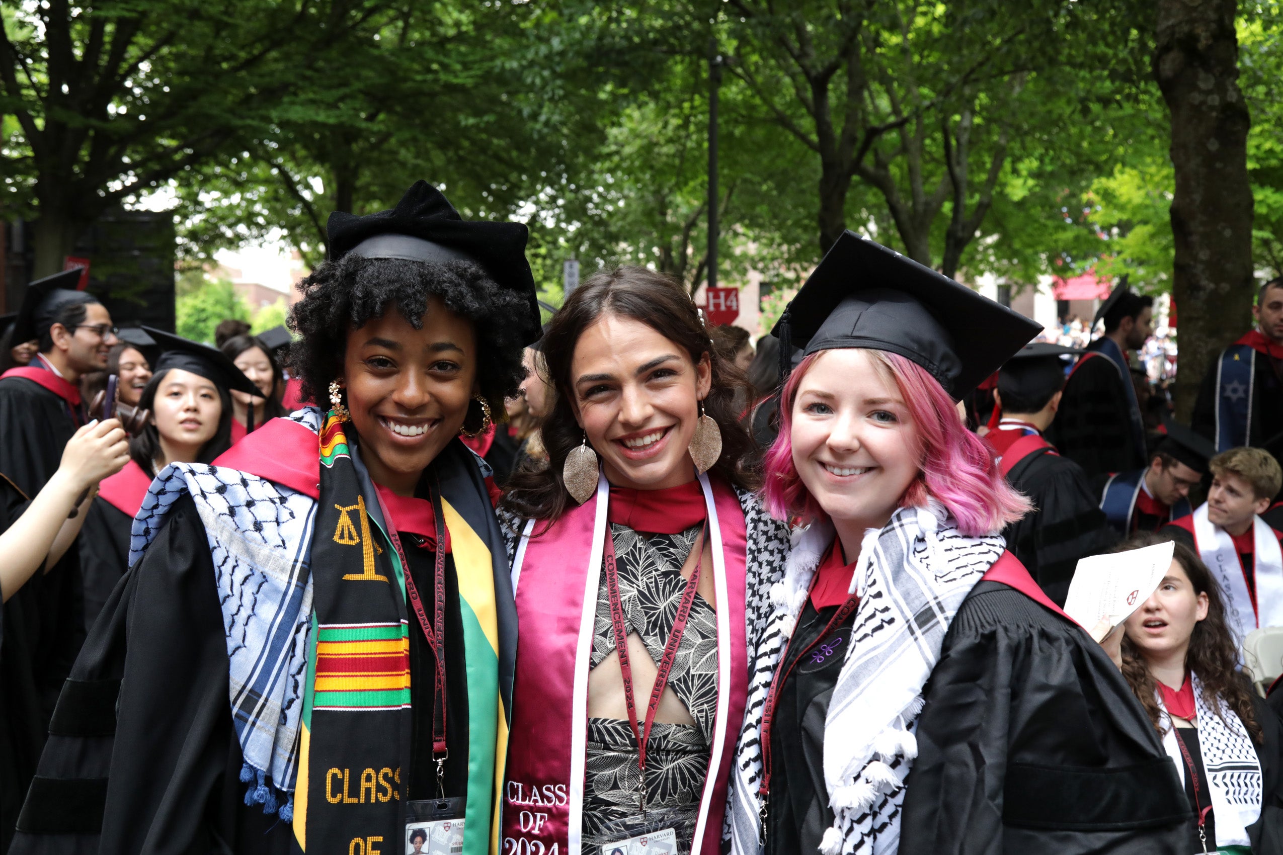 Three graduates smiling in their regalia