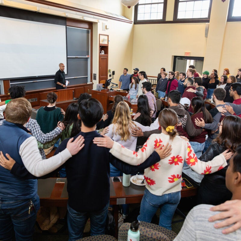 Full classroom of students with hands on shoulders of other students