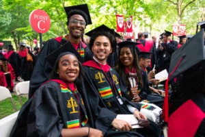 Four graduates smiling