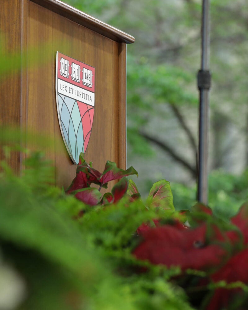 HLS shield on a podium surrounded by flowers