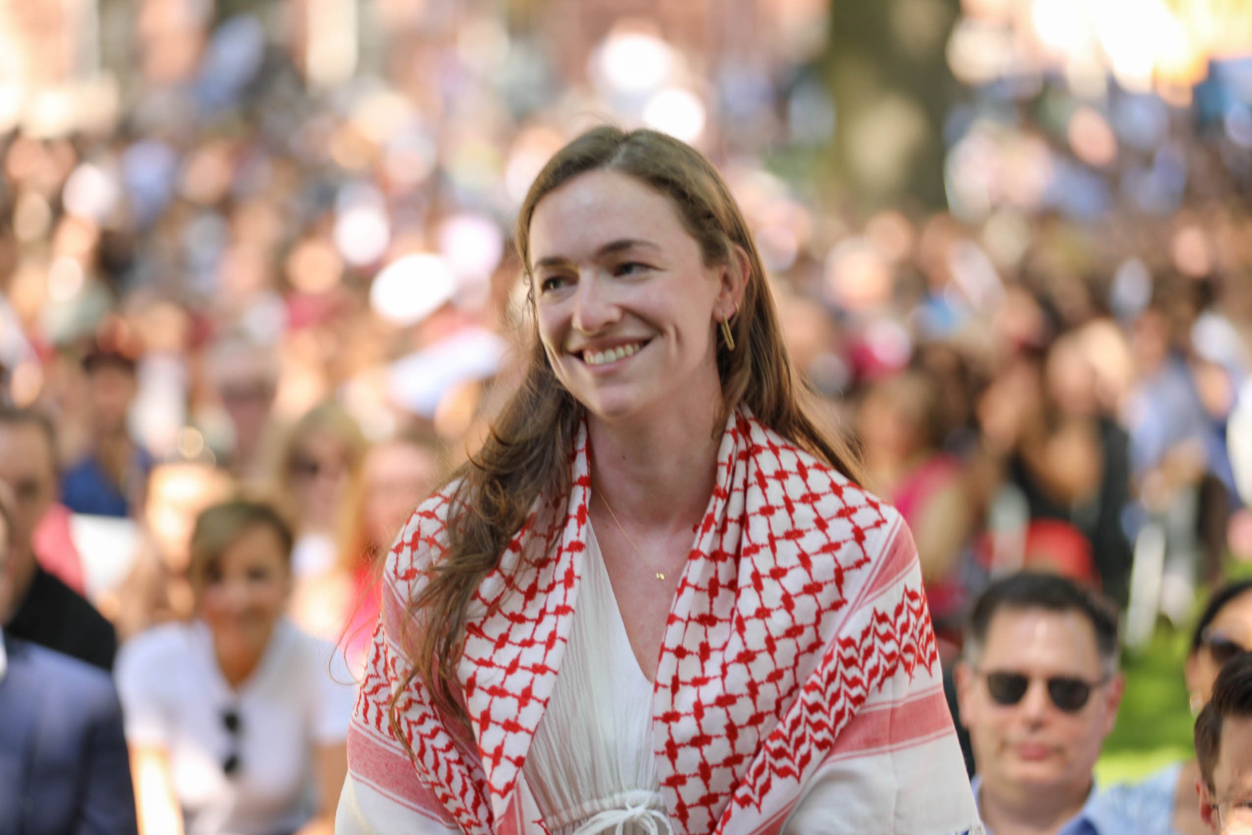 student standing, smiling in a crowd of people