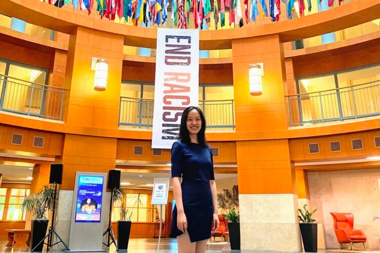A woman stands in a government building with flags