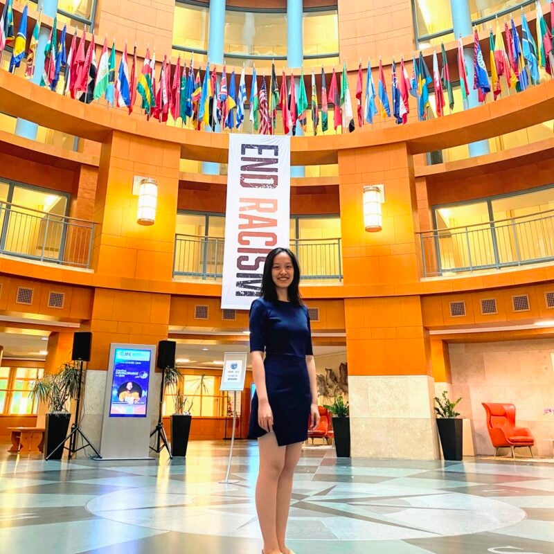 A woman stands in a government building with flags