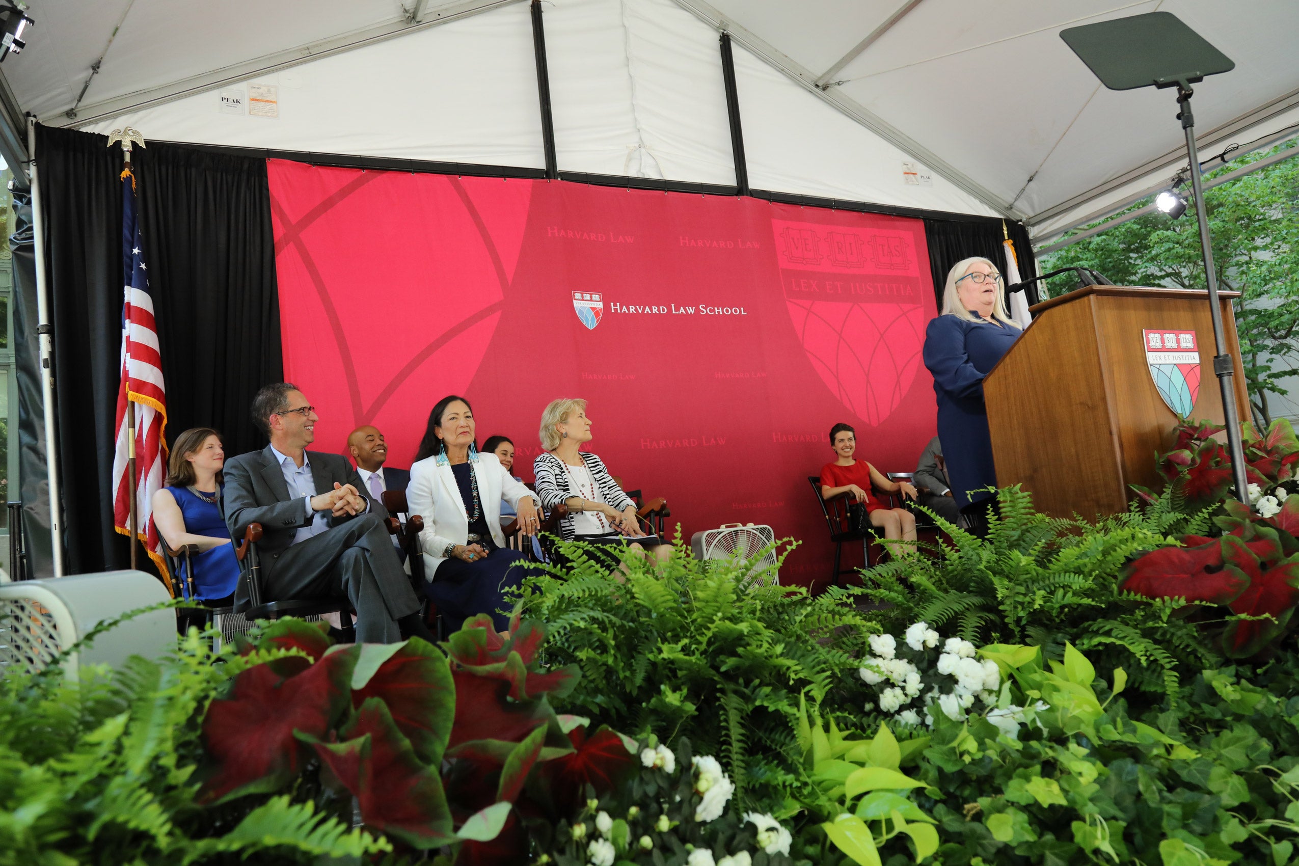 A woman speaking at a podium on stage