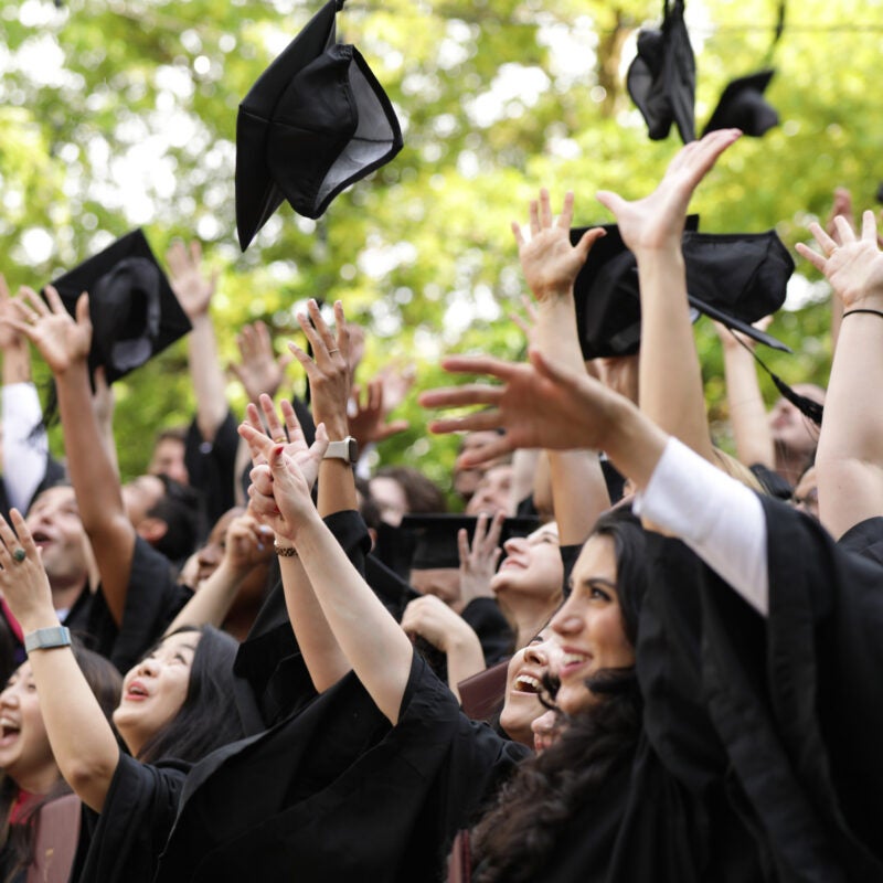 Graduating students tossing their caps into the air