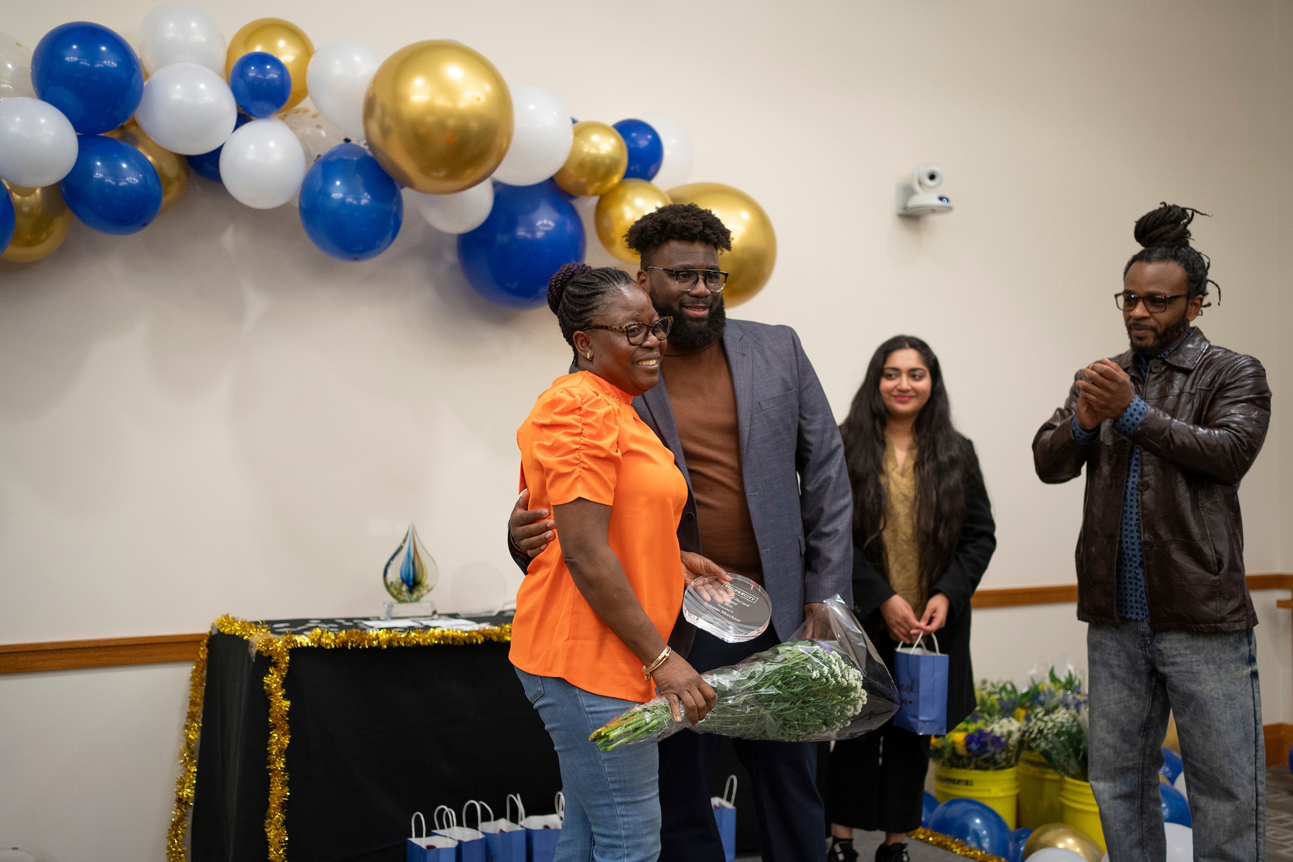 A woman receives an award and flowers.
