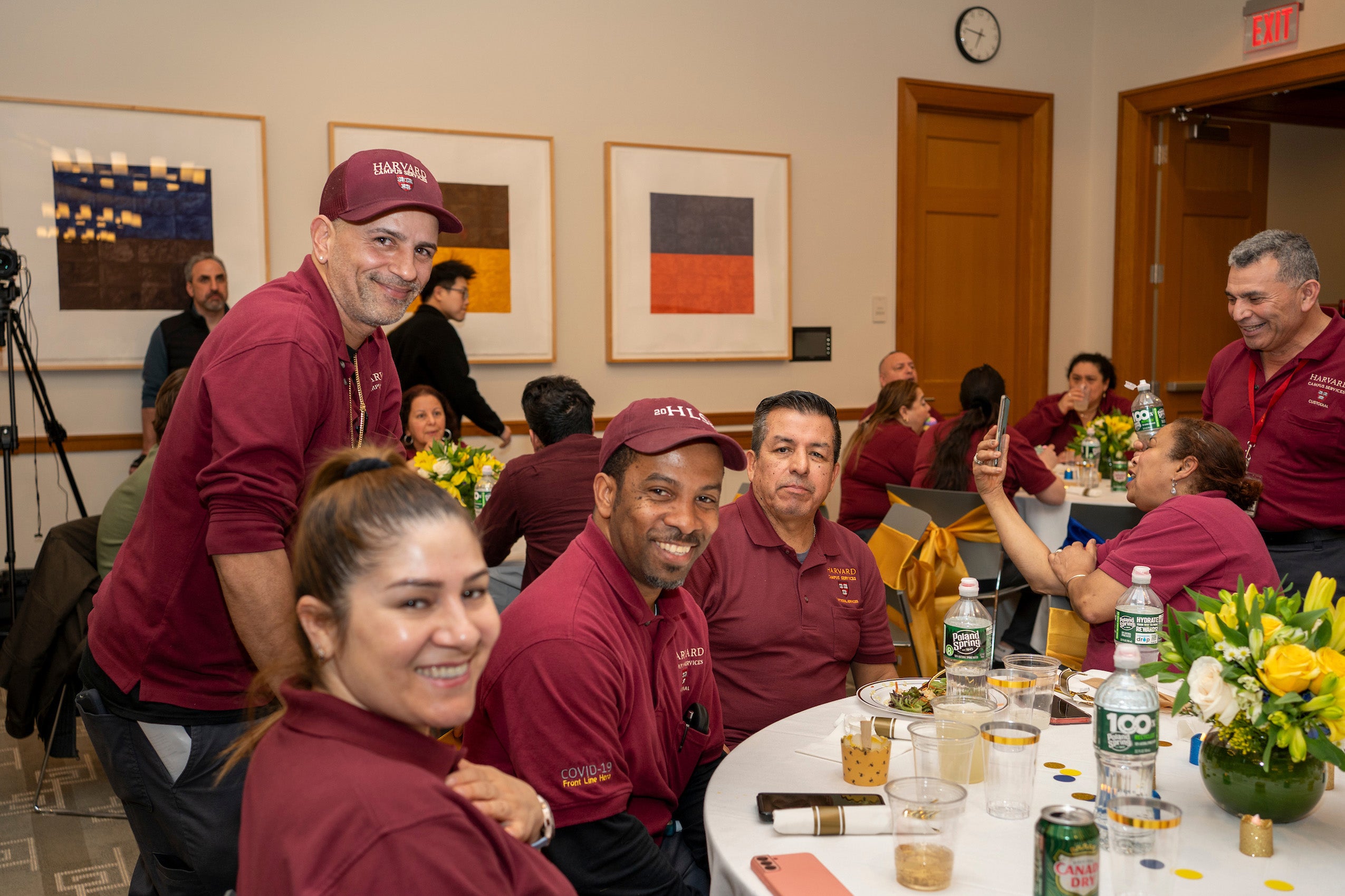 People sitting at a table at an event posing for the camera
