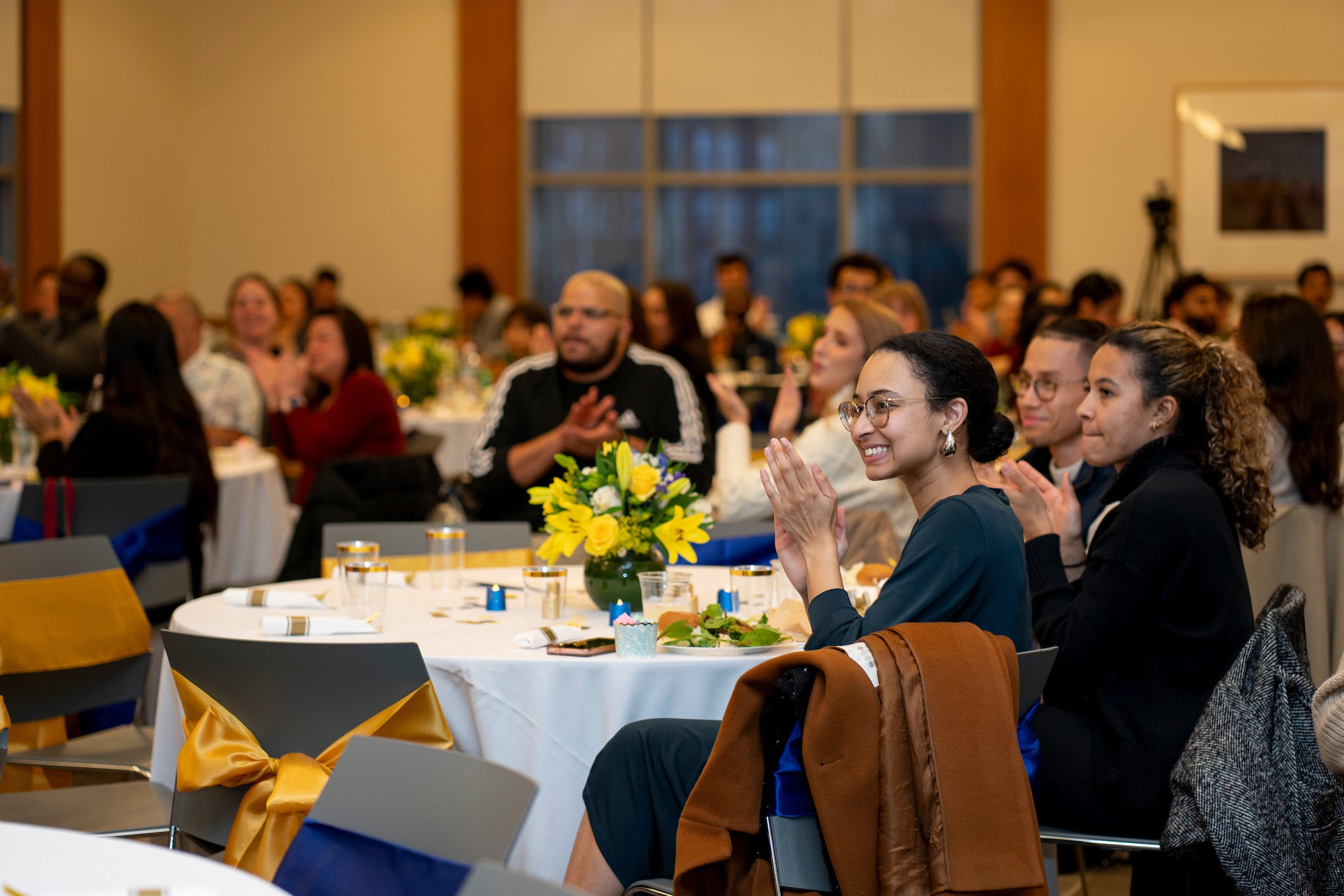 people sitting at a table at an event clapping