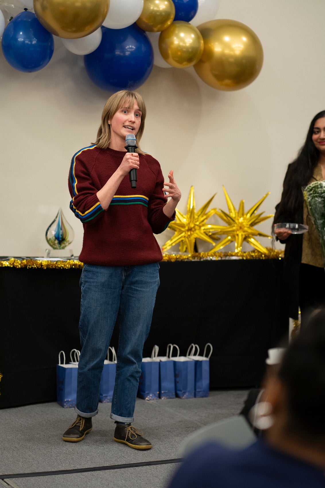 woman speaking into a microphone in front of a room